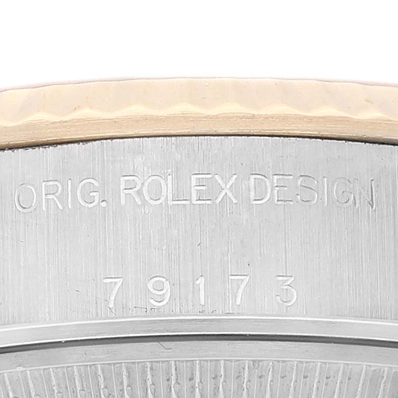 The image shows a close-up of the engraved bezel and part of the case back of a Rolex Datejust 79173 Women's Steel and Gold (two tone) Champagne Dial 79173 Women's Steel and Gold (two tone) Champagne Dial watch.