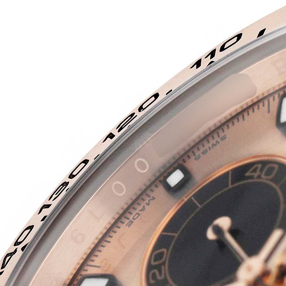 The image shows a close-up of the Rolex Daytona 116505 Men's Rose Gold Pink Dial's bezel and part of the watch face, highlighting the tachymetric scale and subdial.
