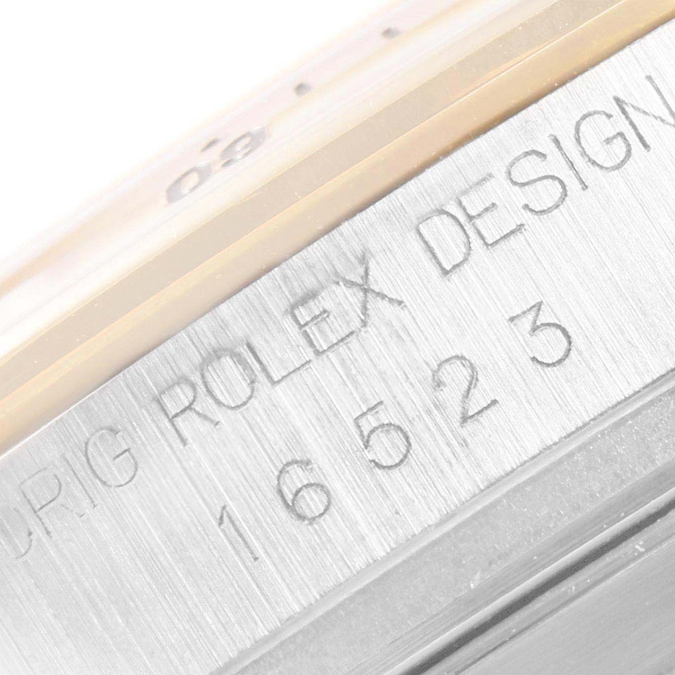 The image shows a close-up of the side of a Rolex Daytona 116523 Men
s Steel and Gold (two tone) White Dial 116523 Men
s Steel and Gold (two tone) White Dial watch, highlighting the model number and "Rolex Design" engraving.