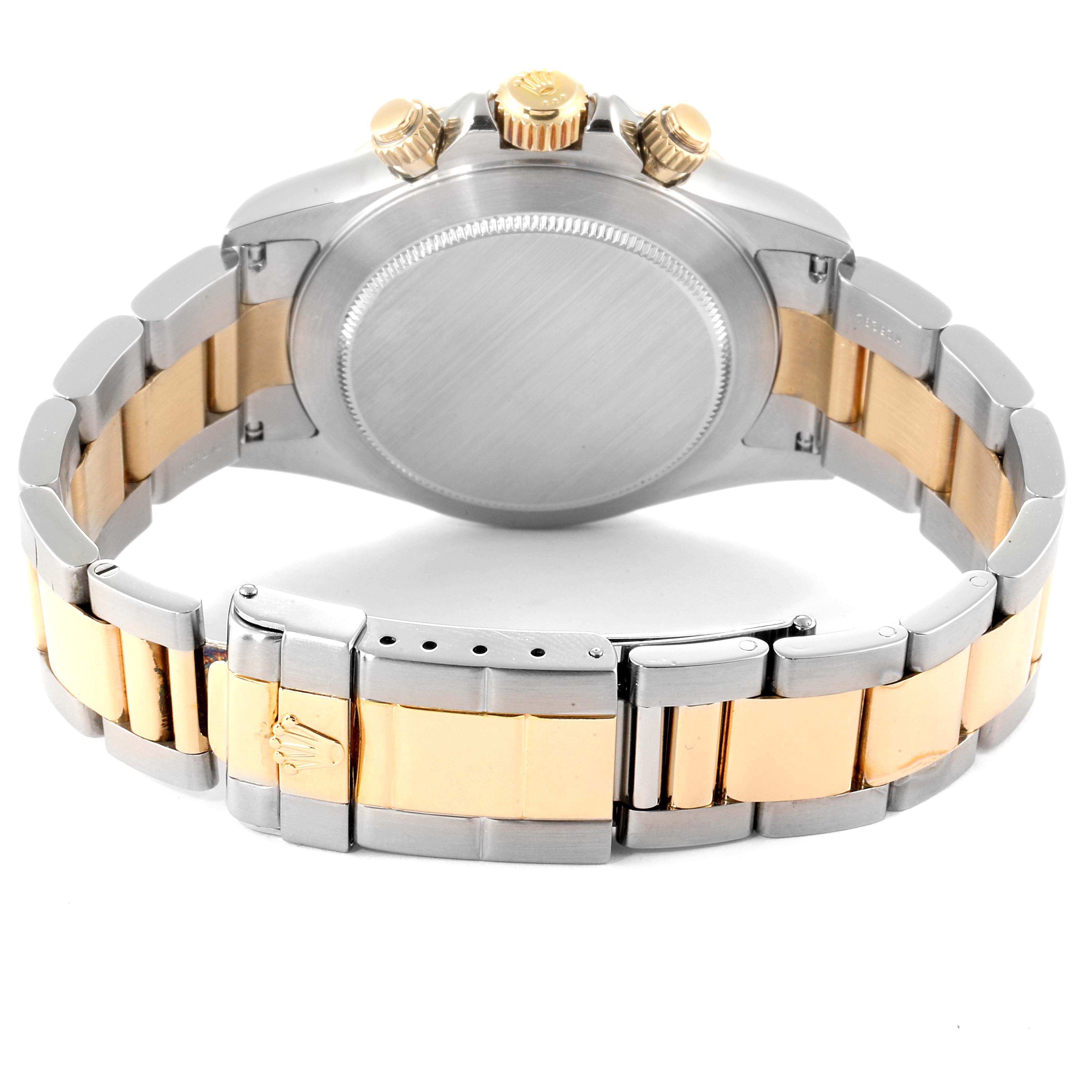 The image shows the back case, crown, and two-tone bracelet of a Rolex Daytona 116523 Men
s Steel and Gold (two tone) White Dial 116523 Men
s Steel and Gold (two tone) White Dial watch.
