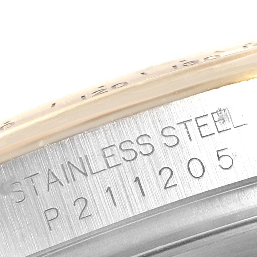 This close-up shows part of the stainless steel case and bezel of a Rolex Daytona 116523 Men
s Steel and Gold (two tone) White Dial 116523 Men
s Steel and Gold (two tone) White Dial watch, with visible engraving.