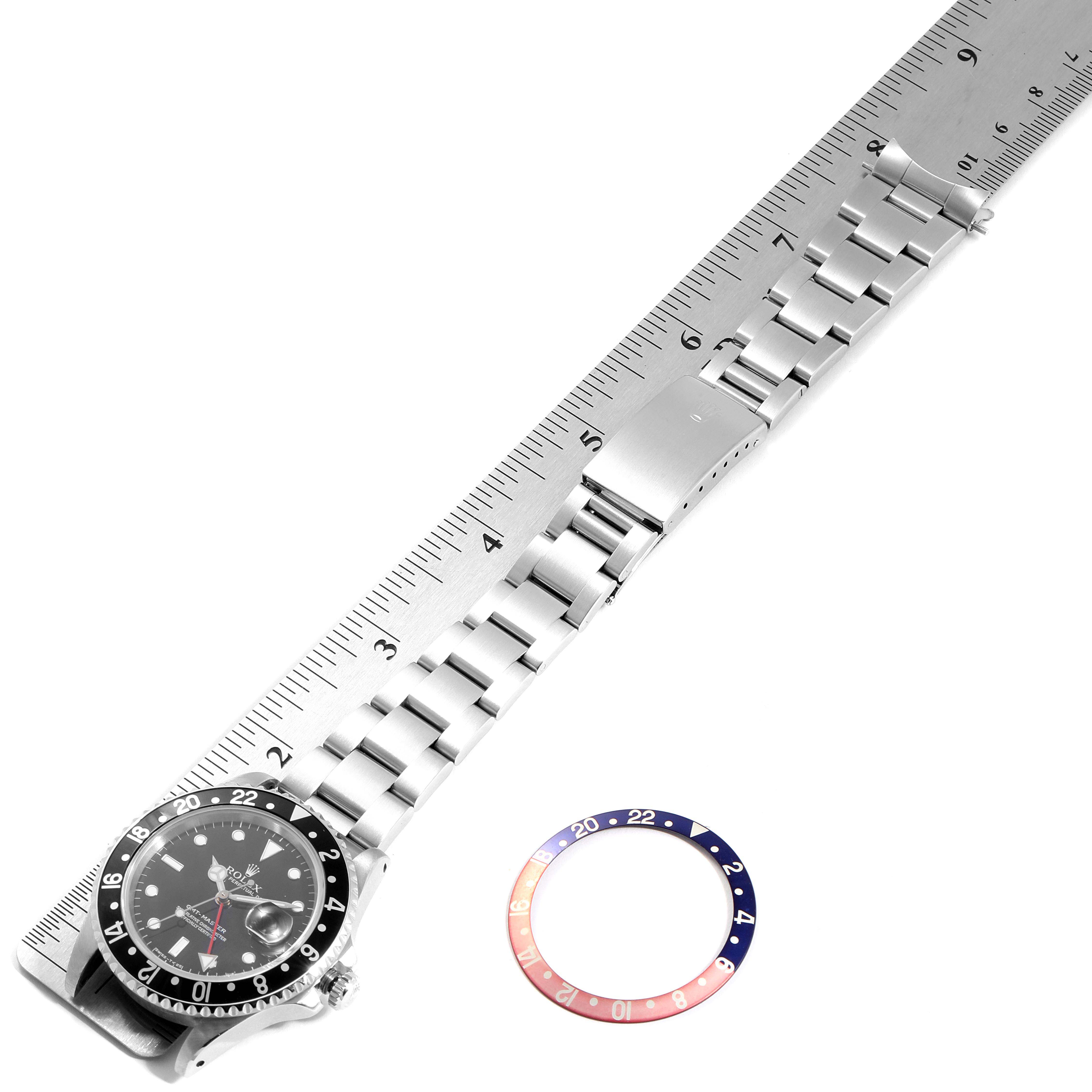 The image shows a Rolex GMT-Master 16700 Men's Stainless Steel Black Dial 16700 Men's Stainless Steel Black Dial watch laid flat with its bracelet fully extended, alongside a bezel insert with a red and blue gradient.
