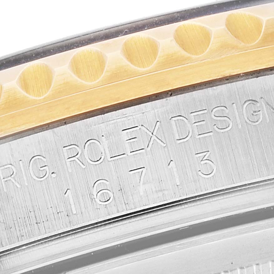 This image shows a close-up of the side of a Rolex Submariner 16713 Men's Steel and Gold (two tone) Champagne Dial 16713 Men's Steel and Gold (two tone) Champagne Dial, highlighting the model number and part of the bezel.