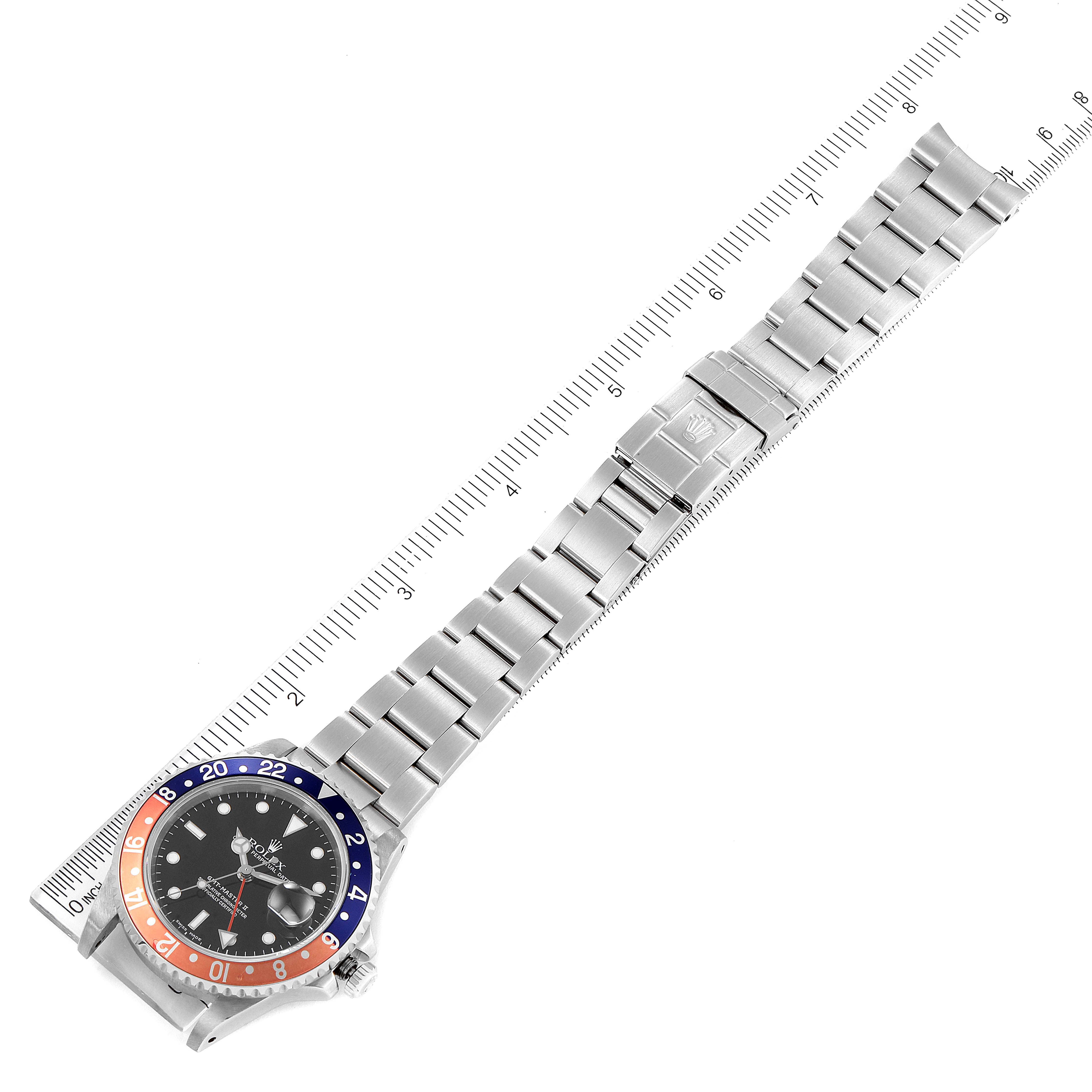 This image shows a Rolex GMT-Master 16710 Men
s Stainless Steel Black Dial 16710 Men
s Stainless Steel Black Dial watch laid flat, displaying the full length of the watch and its bracelet alongside a ruler.