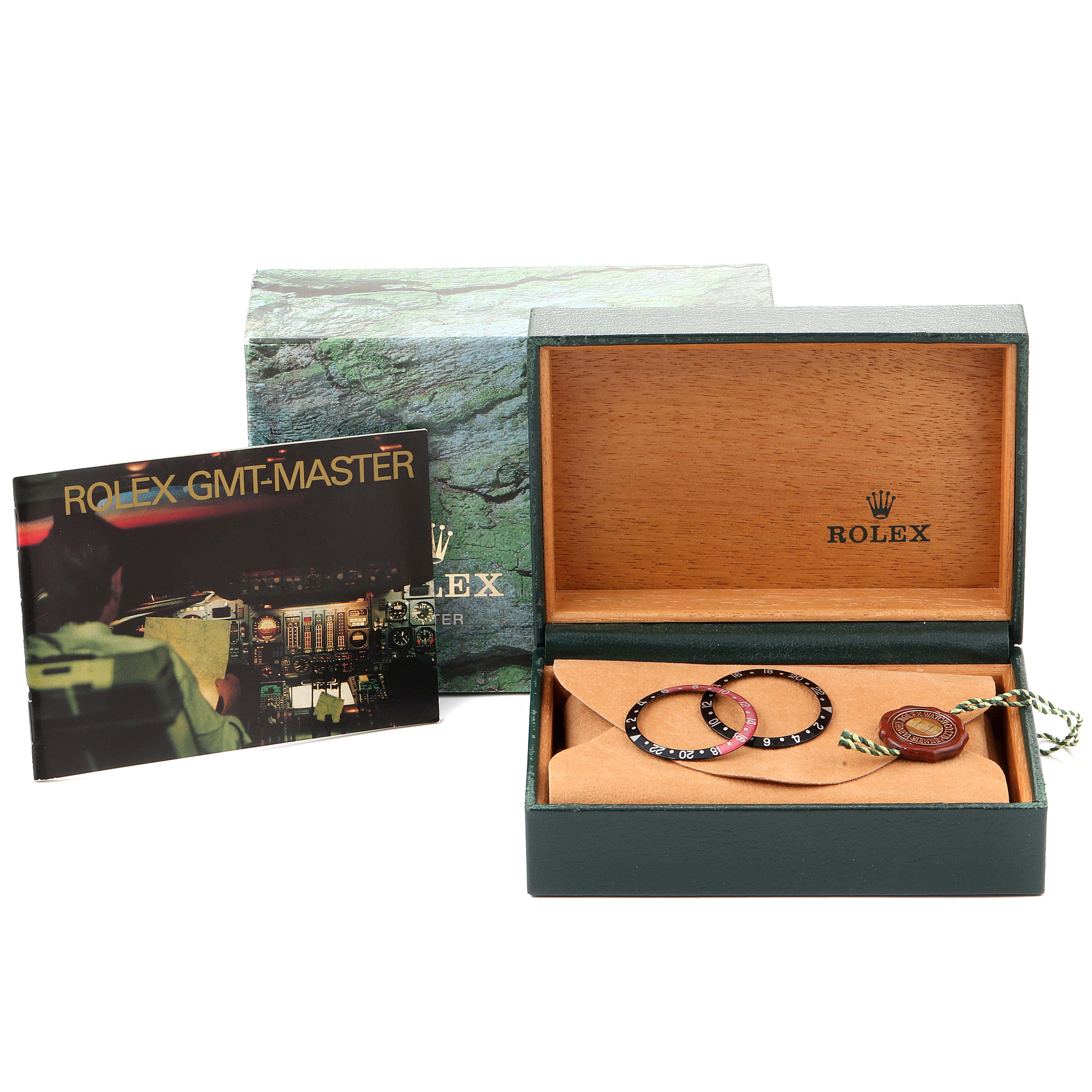 The image shows the accessories for a Rolex GMT-Master 16710 Men's Stainless Steel Black Dial 16710 Men's Stainless Steel Black Dial model, including the box, booklet, bezel rings, and a tag.