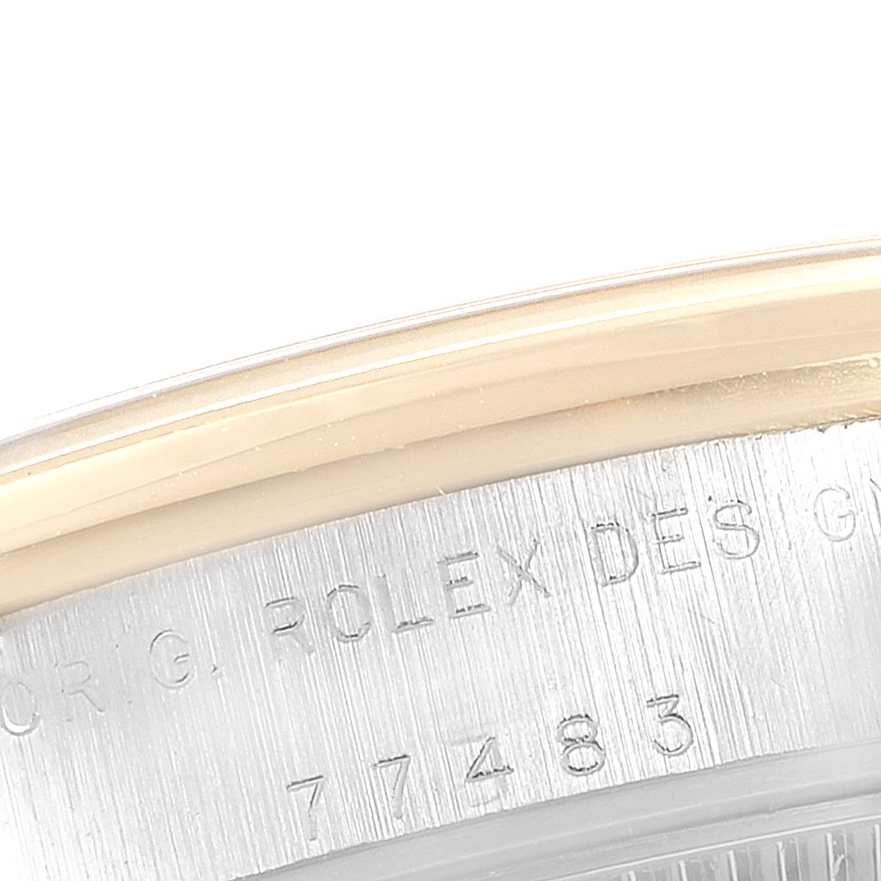 This close-up image of the Rolex Mid-Size 77483 Women
s Steel and Gold (two tone) Grey Dial 77483 Women
s Steel and Gold (two tone) Grey Dial model focuses on the case side, revealing part of the bezel and the engraved serial number.
