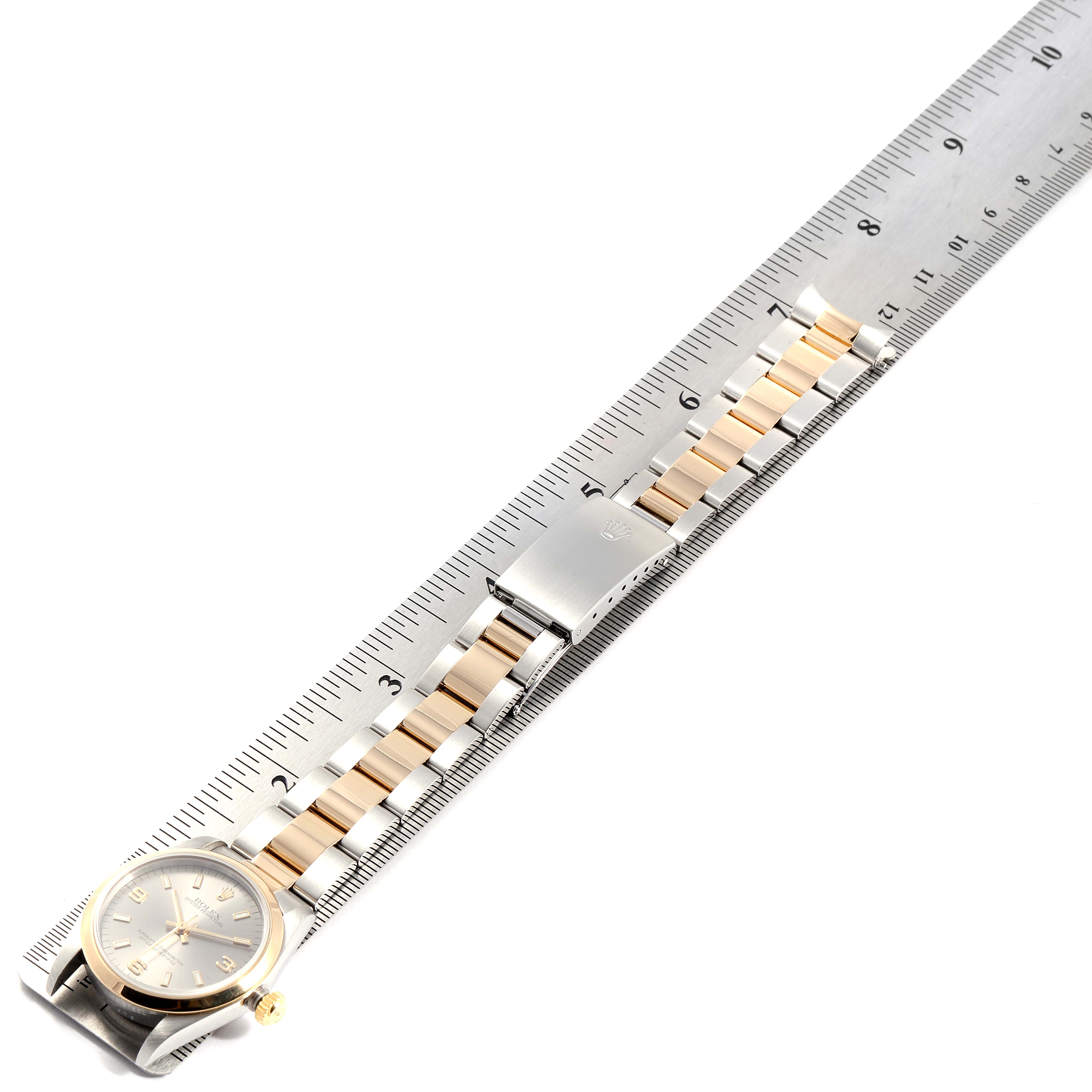 The Rolex Mid-Size 77483 Women
s Steel and Gold (two tone) Grey Dial 77483 Women
s Steel and Gold (two tone) Grey Dial model is shown laid flat with the full bracelet extended alongside a ruler.