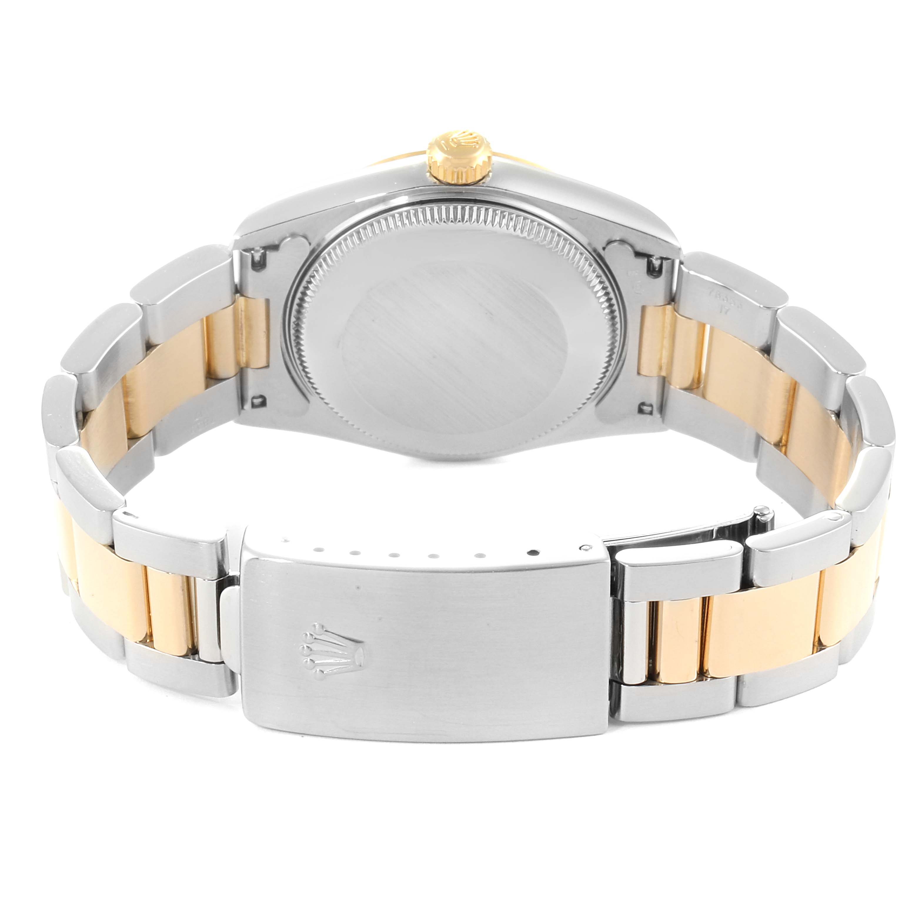 The image shows the back view of a Rolex Mid-Size 77483 Women
s Steel and Gold (two tone) Grey Dial 77483 Women
s Steel and Gold (two tone) Grey Dial watch, displaying the case back, crown, and two-tone bracelet with the clasp.