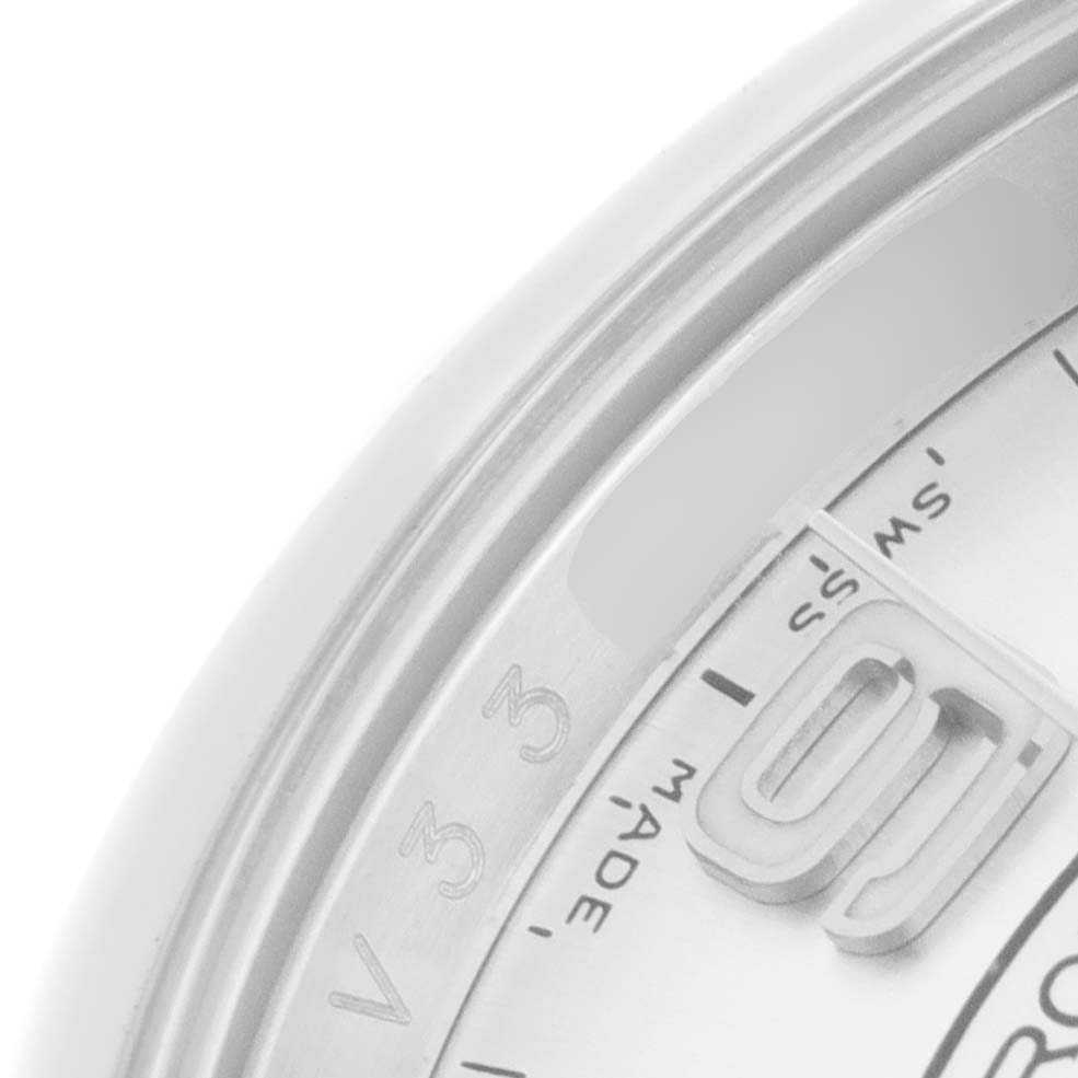 This is a close-up of the date section and partial bezel of a Rolex Oyster Perpetual 116000 Men's Stainless Steel Silver Dial 116000 Men's Stainless Steel Silver Dial watch.