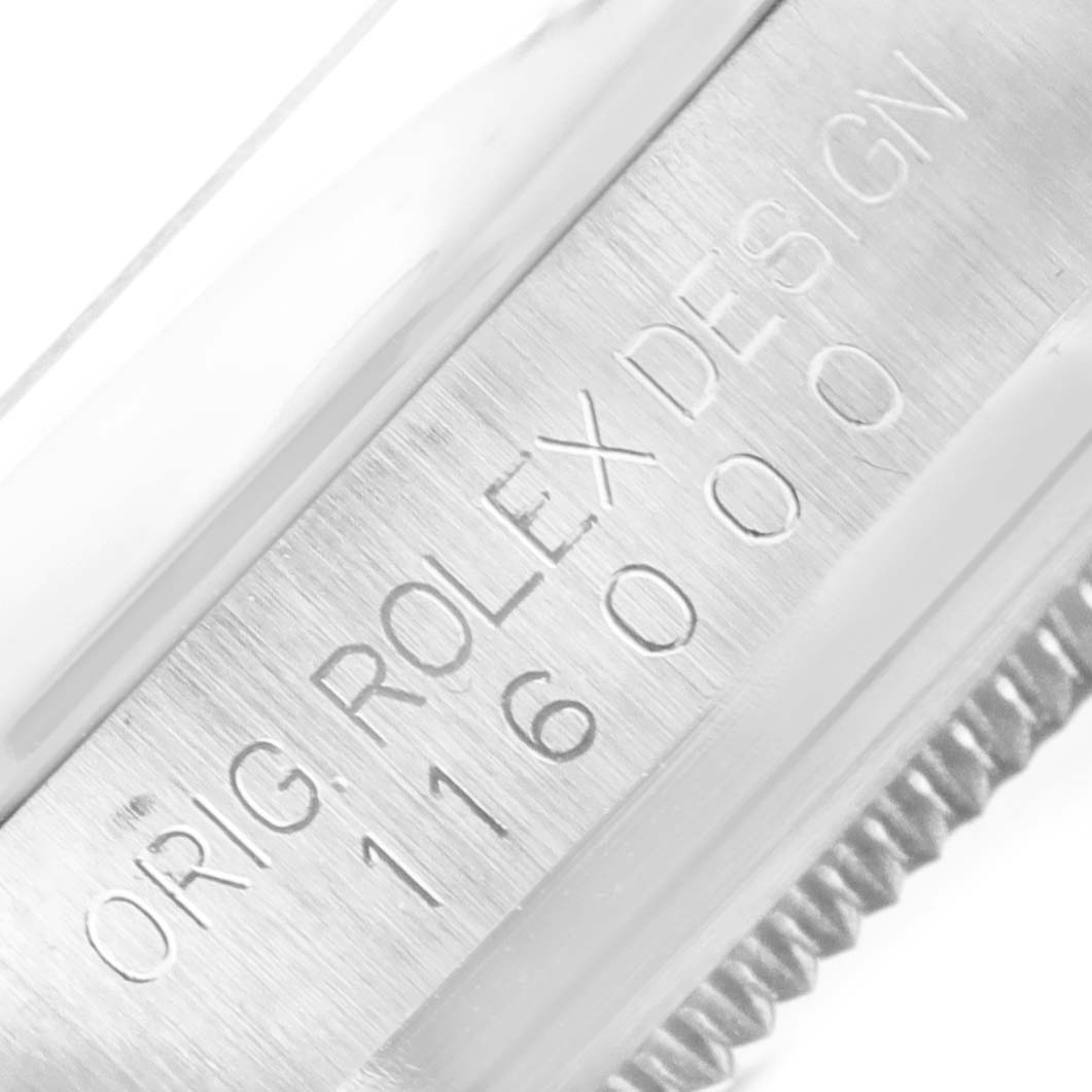 This image shows the side engraving and bezel of a Rolex Oyster Perpetual 116000 Men's Stainless Steel Silver Dial 116000 Men's Stainless Steel Silver Dial watch.