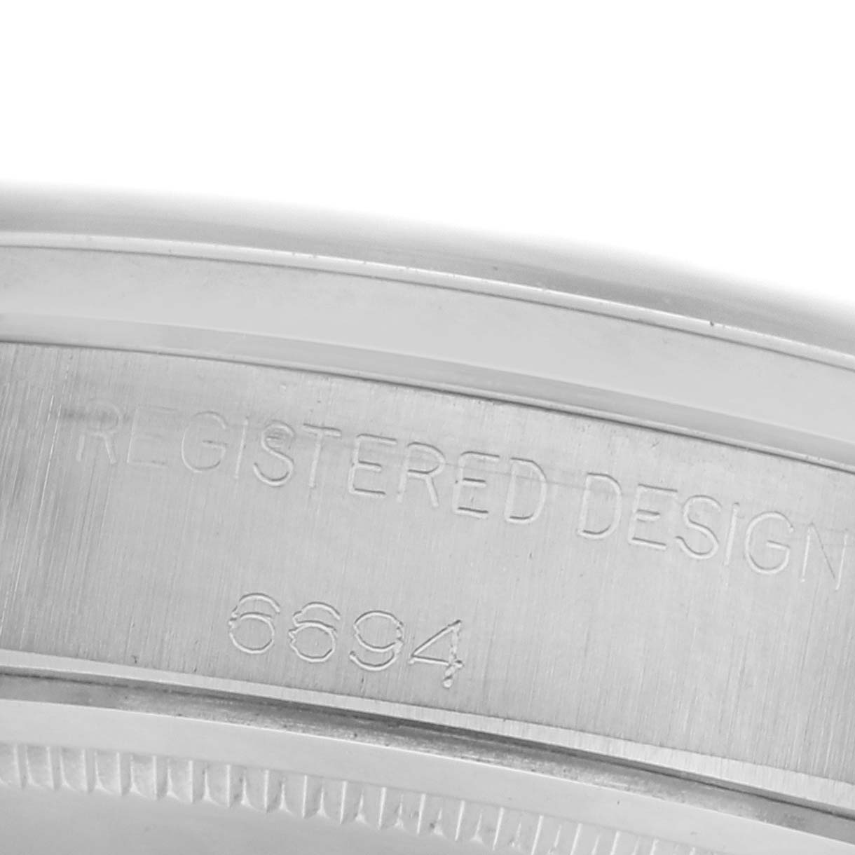 The image shows a close-up of the side engraving on a Rolex Date 6694 Men's Stainless Steel Silver Dial 6694 Men's Stainless Steel Silver Dial model's case.