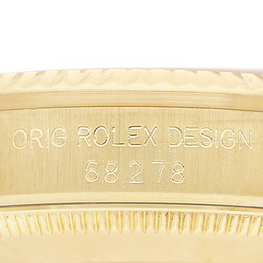 The image shows a close-up angle of the Rolex Datejust 68278 Women's Yellow Gold White Dial's case side with engraved design and model number.