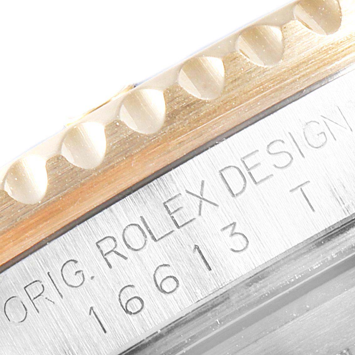 This image shows a close-up of the bezel and part of the case with engraved text of the Rolex Submariner 16613 Men
s Steel and Gold (two tone) Blue Dial 16613 Men
s Steel and Gold (two tone) Blue Dial model.