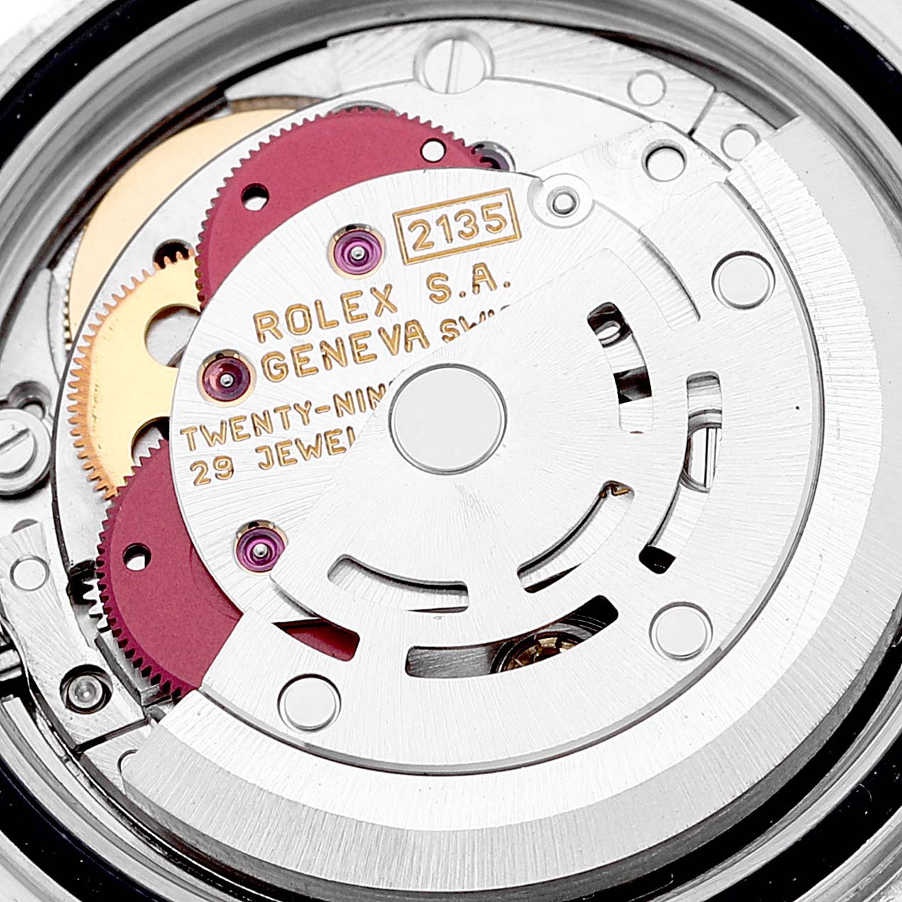 The image shows a close-up of the movement mechanism of a Rolex Yacht-Master 69623 Women's Steel and Gold (two tone) White Dial 69623 Women's Steel and Gold (two tone) White Dial watch, displaying gears and engravings.