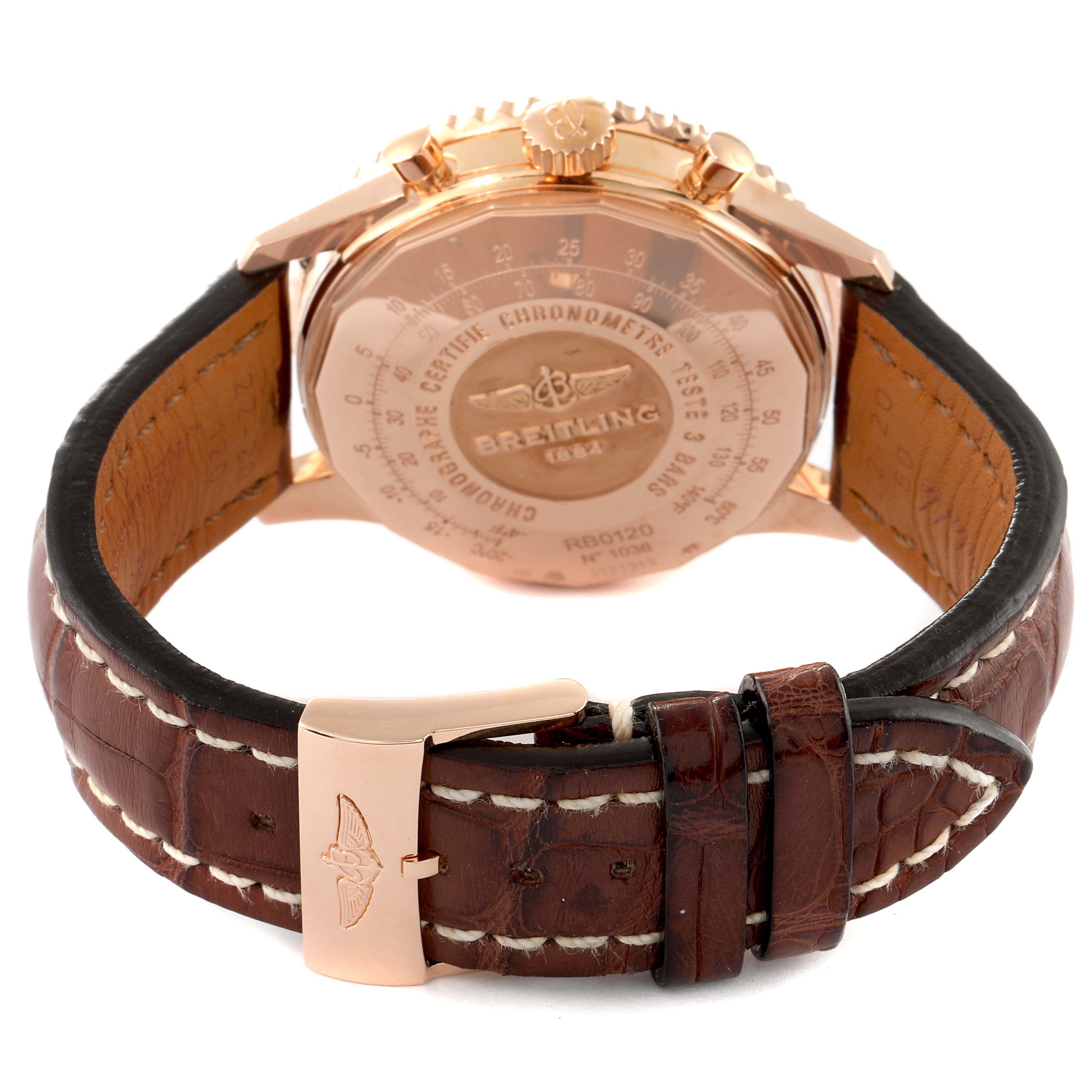 The image shows the back view of the Breitling Navitimer RB0120 Men's Rose Gold Black Dial RB0120 Men's Rose Gold Black Dial watch and its brown leather strap with a gold buckle.