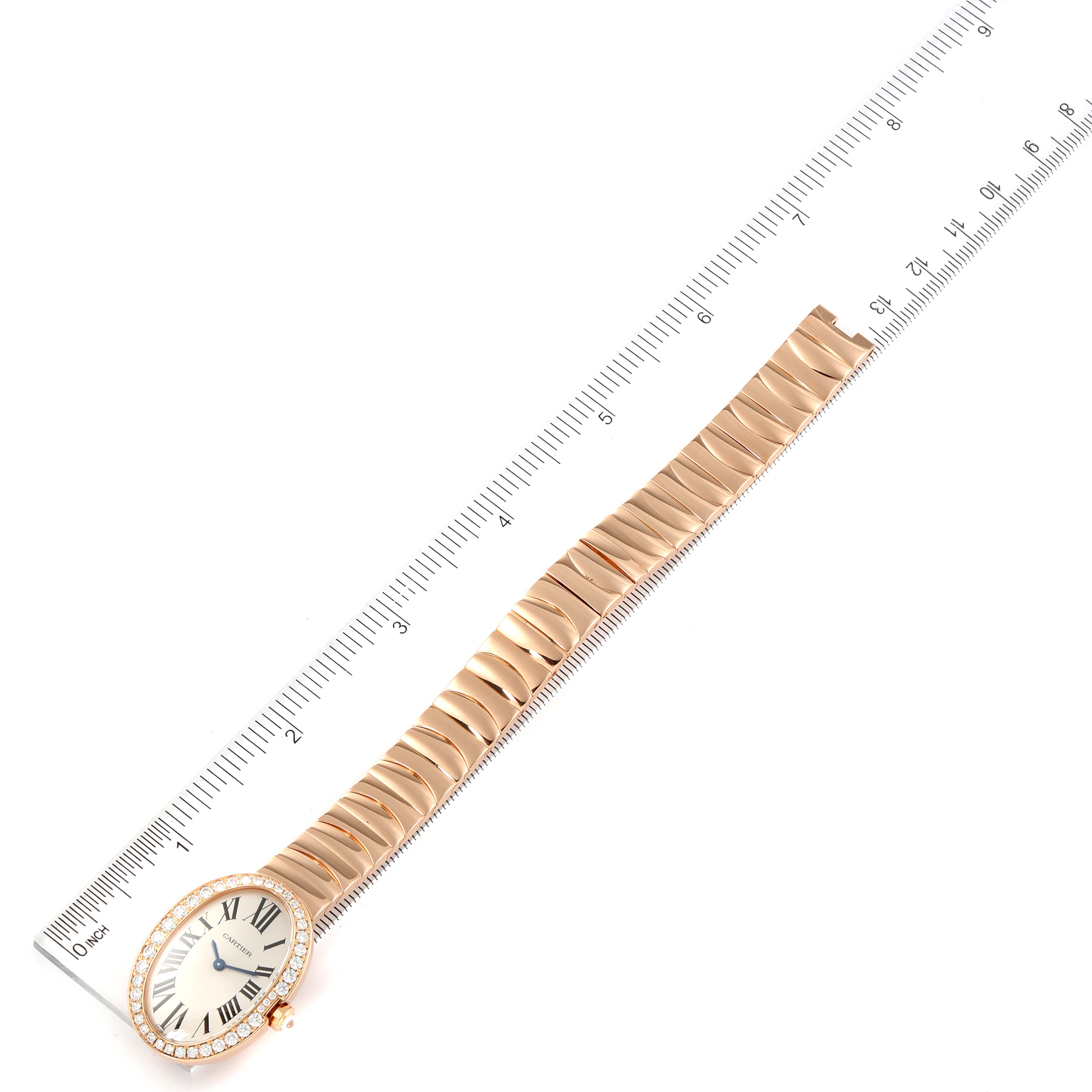 The image shows an overhead view of a Cartier Baignoire WB520002 Women's Rose Gold Silver Dial WB520002 Women's Rose Gold Silver Dial watch with a gold bracelet band, next to a ruler for scale.