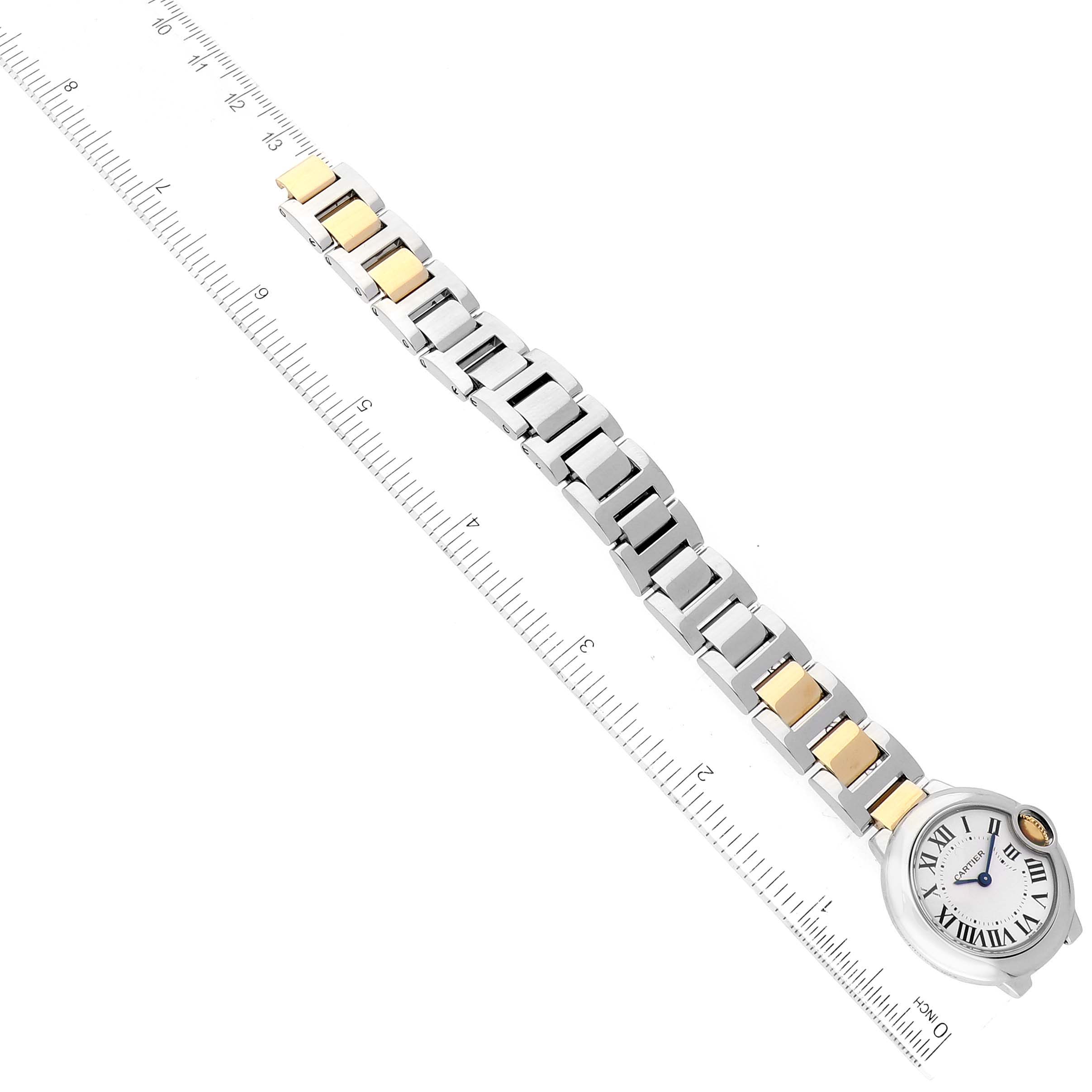 The image shows a Ballon Bleu model by Cartier, displaying its band and face, photographed alongside a ruler for size reference.