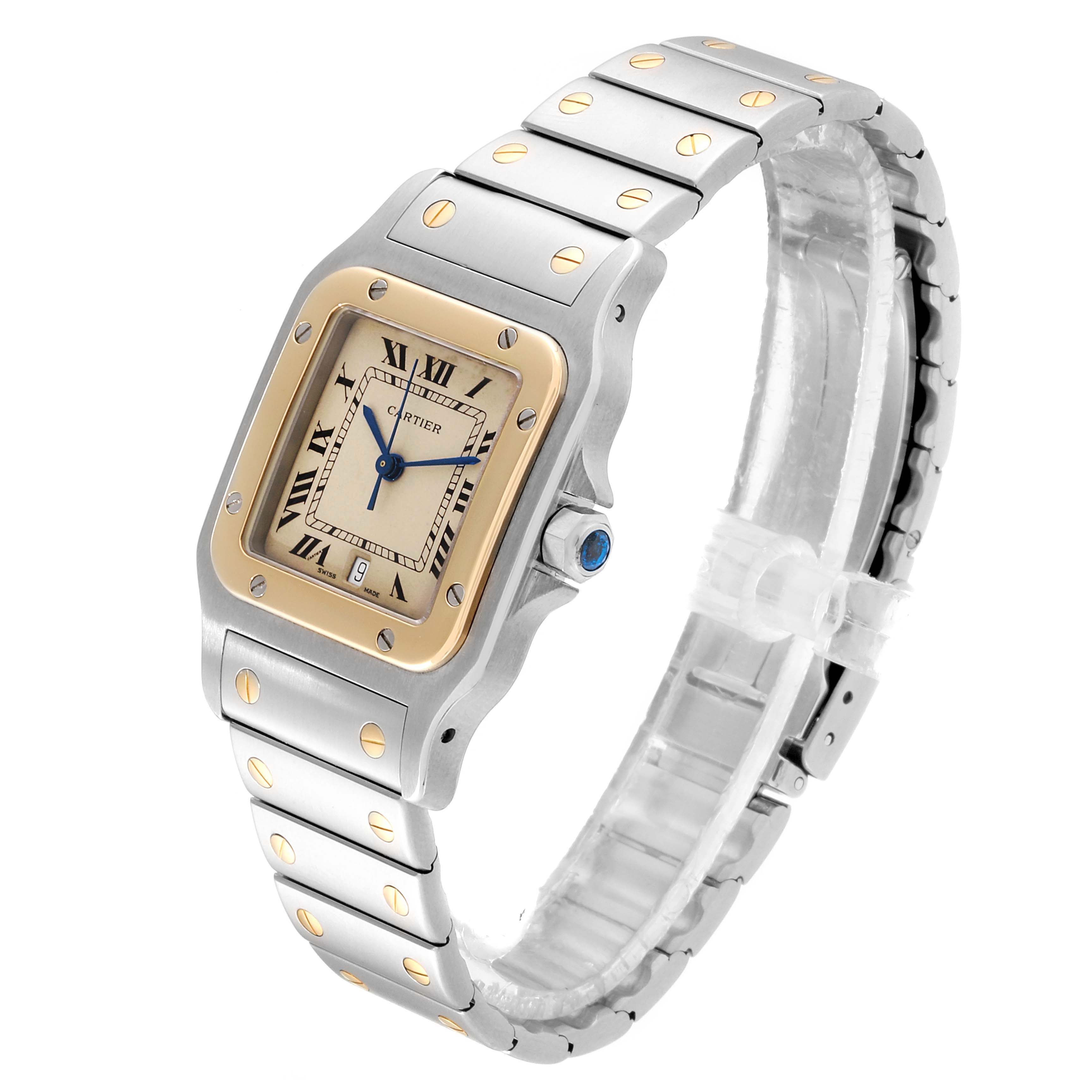The image shows a Cartier Santos 187901 Men
s Steel and Gold (two tone) Beige Dial 187901 Men
s Steel and Gold (two tone) Beige Dial watch at an angled view, highlighting its face, bezel, crown, and bracelet.