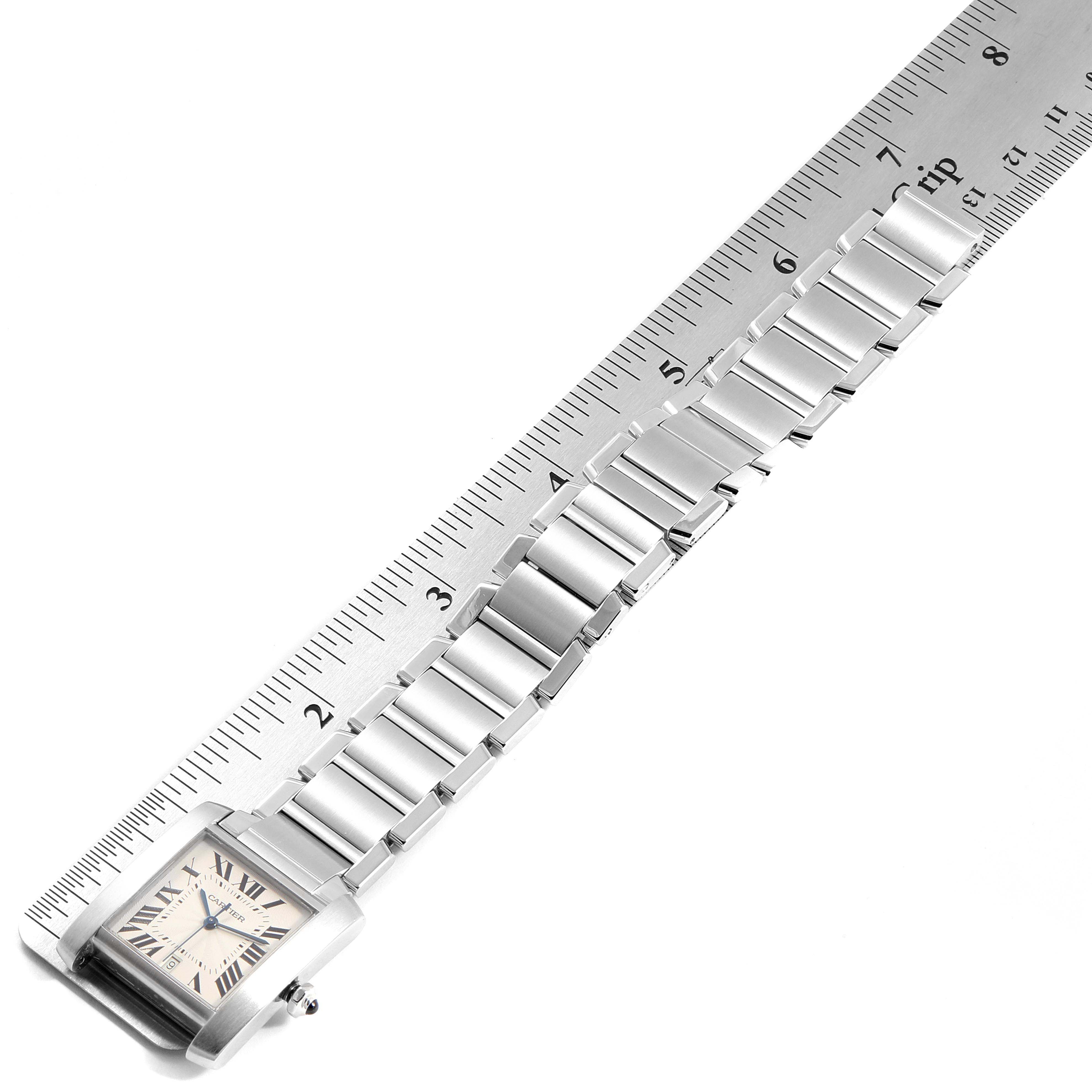 This image shows a Cartier Tank Francaise W51002Q3 Men's Stainless Steel Silver Dial W51002Q3 Men's Stainless Steel Silver Dial watch positioned next to a ruler, displaying its face and metal bracelet.