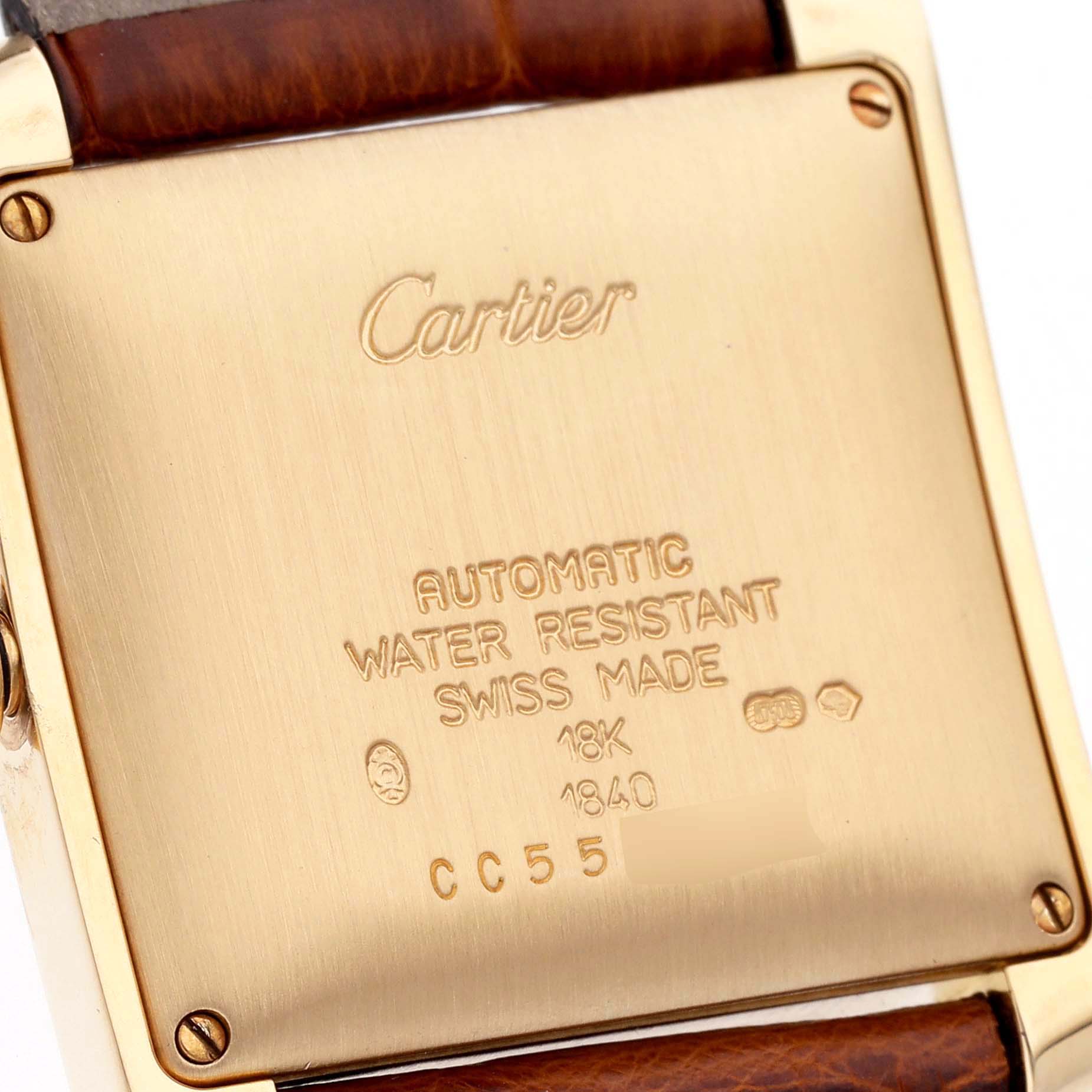 The image shows the back case of a Cartier Tank Francaise W5000156 Men
s Yellow Gold Silver Dial W5000156 Men
s Yellow Gold Silver Dial watch with engravings and part of the leather strap.