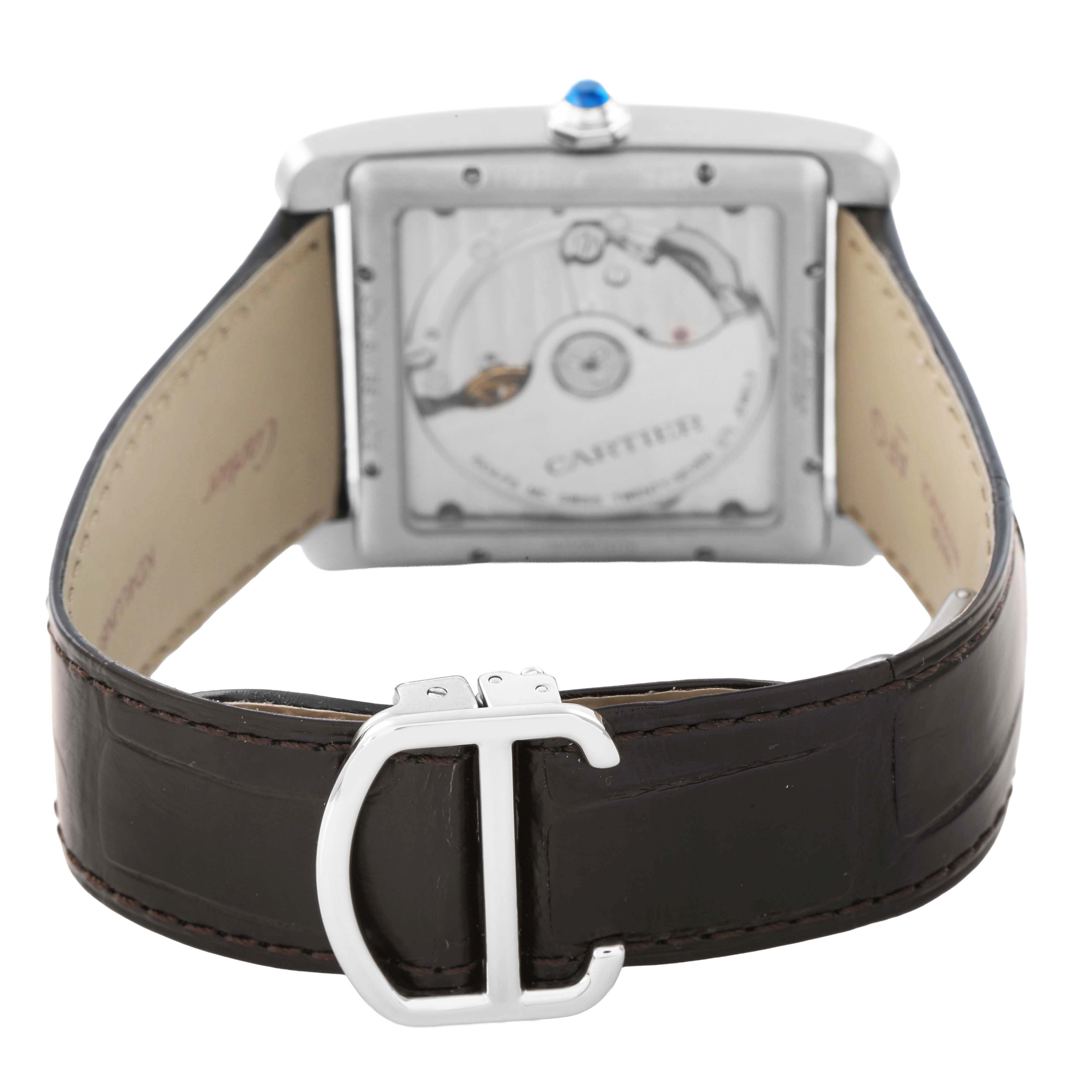 The image shows the back view of a Cartier Tank MC W5330004 Men's Stainless Steel Black Dial watch, highlighting the movement and leather strap with a deployment clasp.