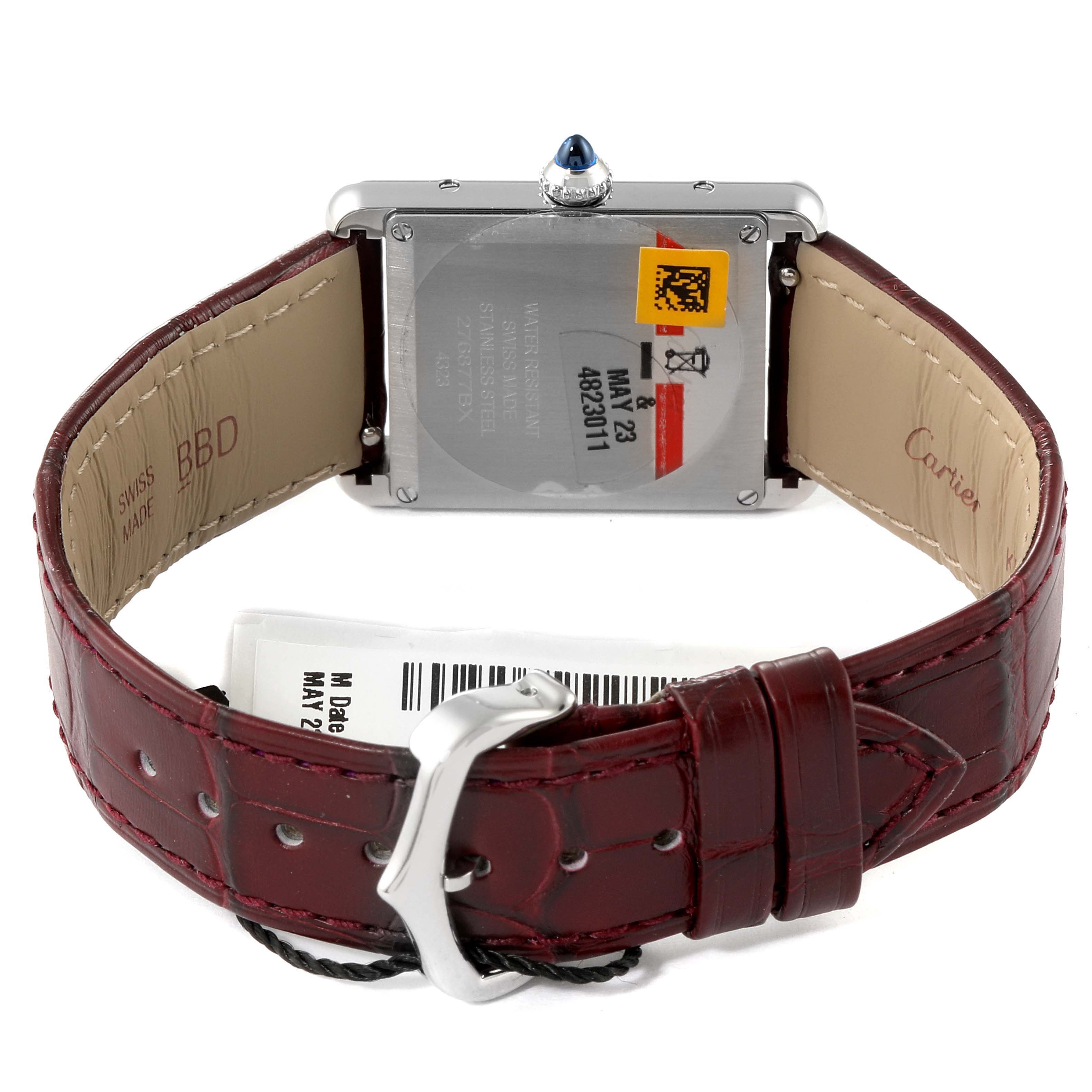 The image shows the back of a Cartier Tank Must WSTA0054 Women's Stainless Steel Red Dial WSTA0054 Women's Stainless Steel Red Dial watch with its leather strap and buckle visible.