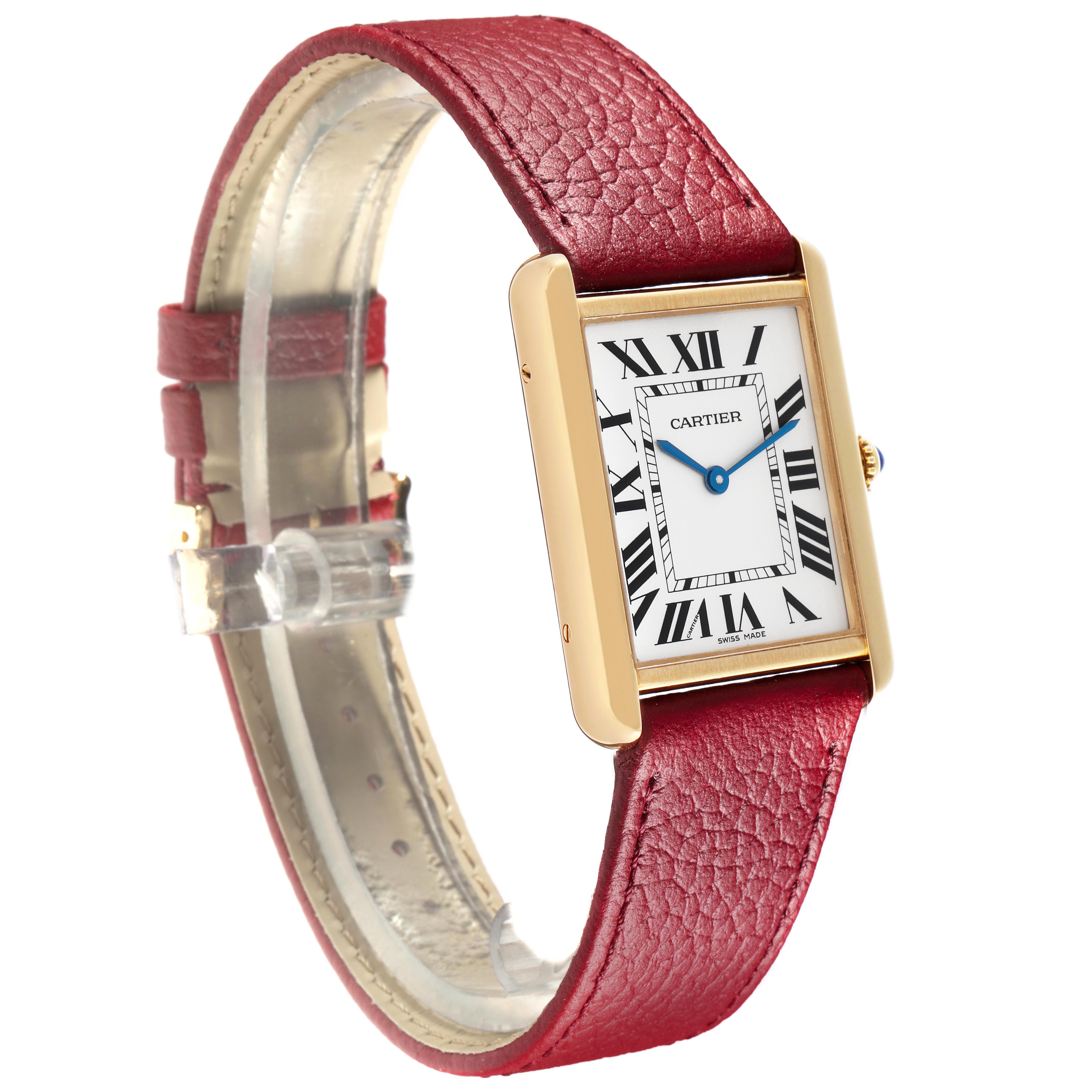 The Cartier Tank Solo W1018855 Men
s Steel and Gold (two tone) Silver Dial watch is shown at a slight angle, displaying its rectangular face, gold case, blue hands, and red leather strap.