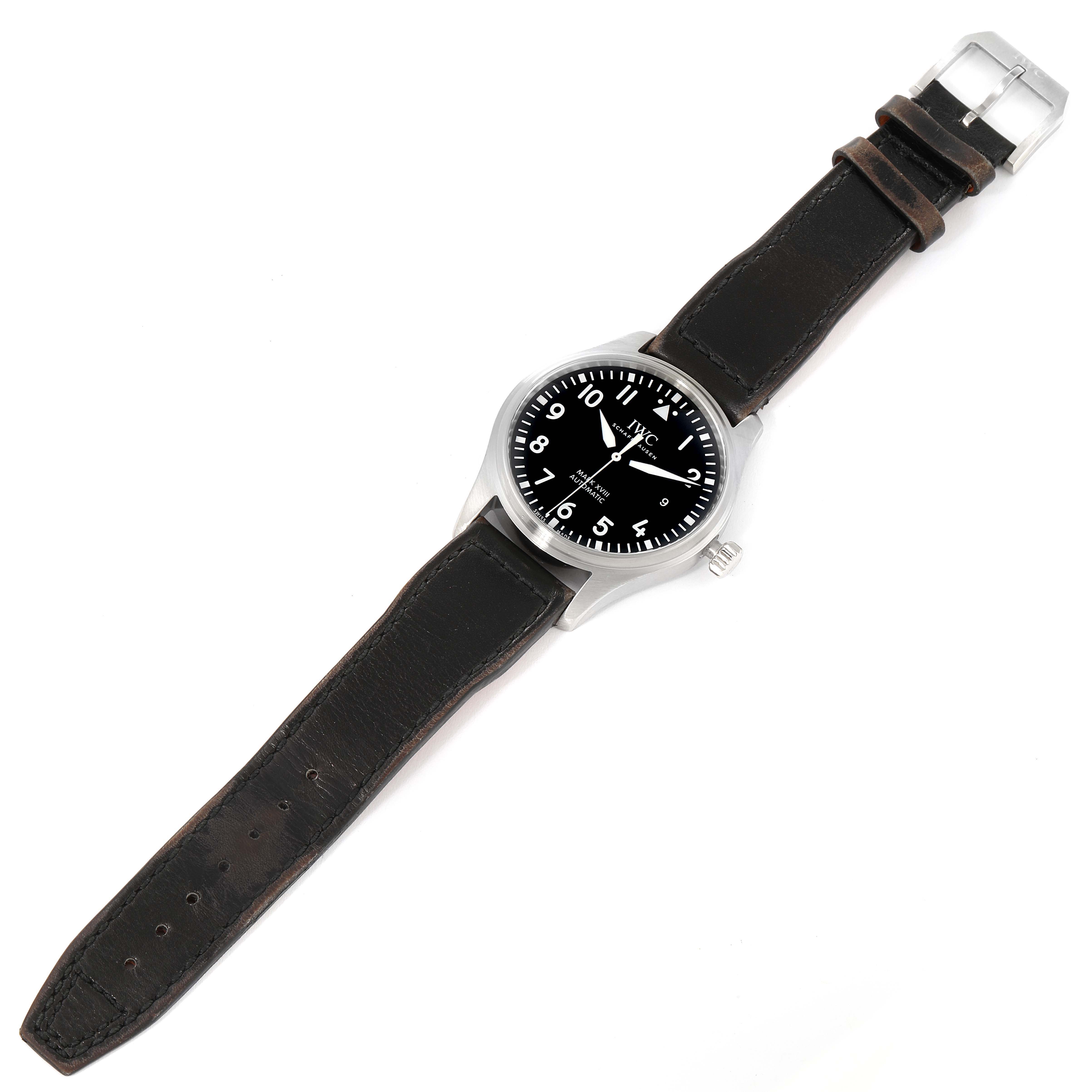 The image shows an IWC Pilot IW327001 Men
s Stainless Steel Black Dial IW327001 Men
s Stainless Steel Black Dial watch lying flat, displaying its black face, silver bezel, crown, and black leather strap.