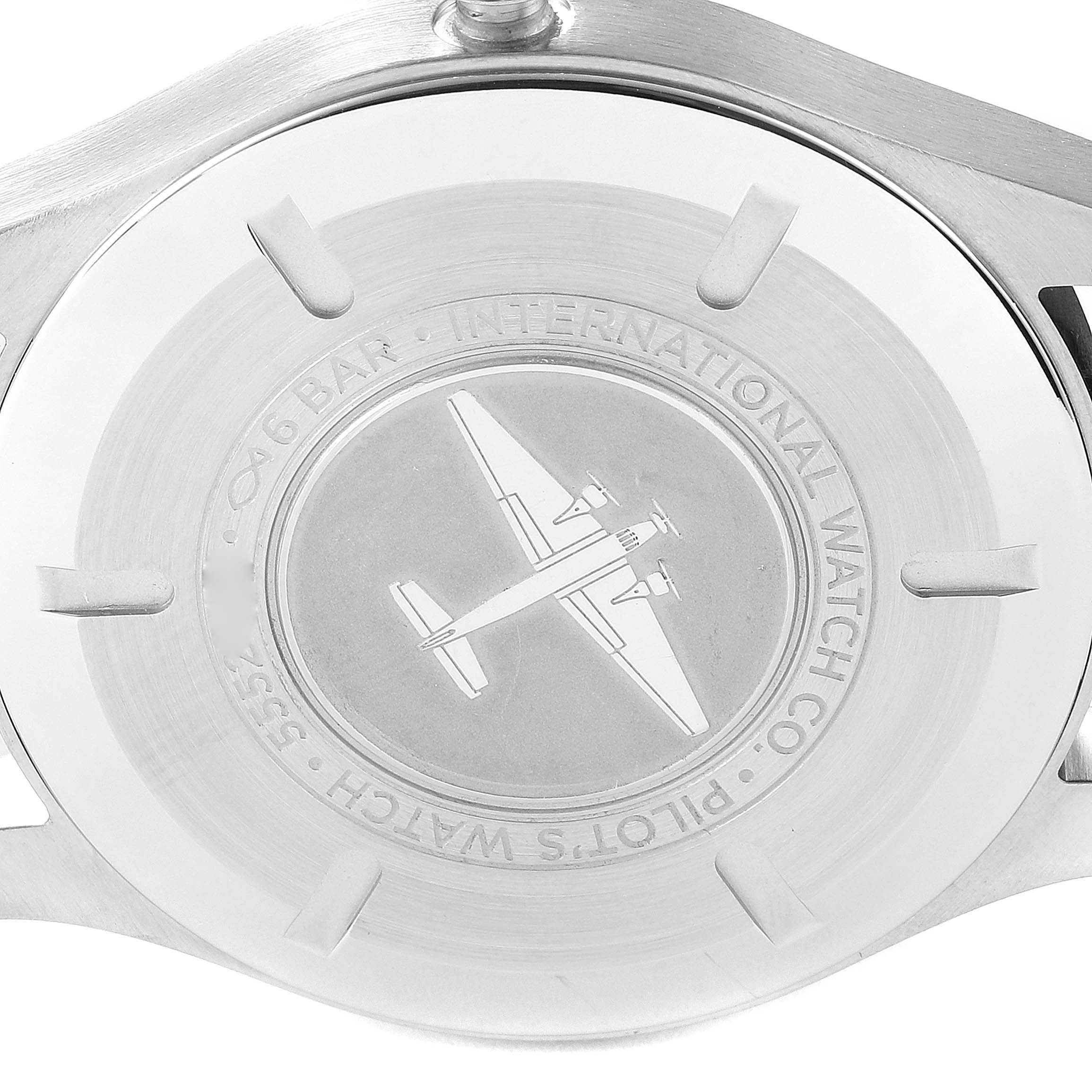 This image shows the case back of a Pilot model watch by IWC, featuring an engraved airplane and branding.