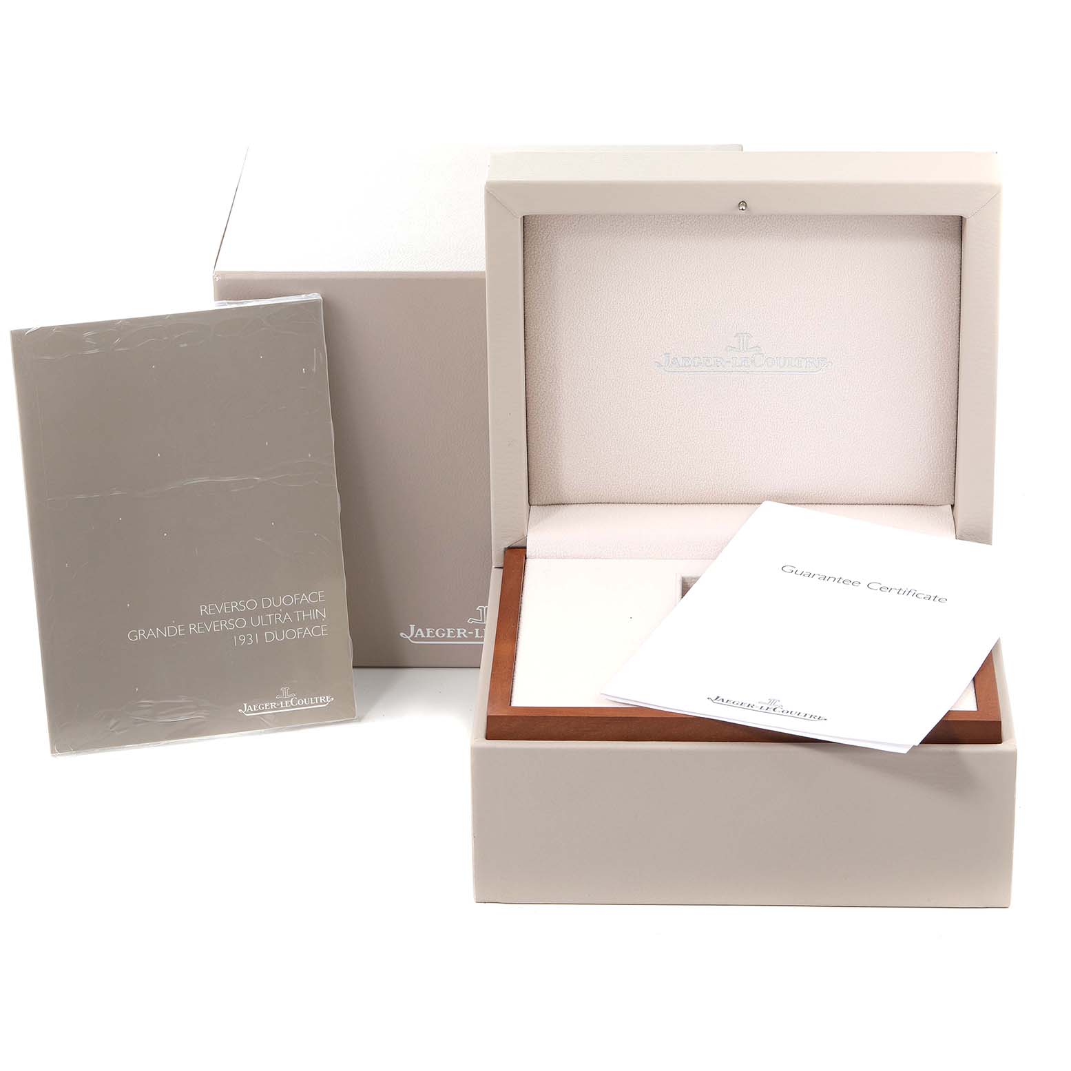 This image shows the packaging, presentation box, instruction manual, and guarantee certificate for a Jaeger-LeCoultre Reverso.