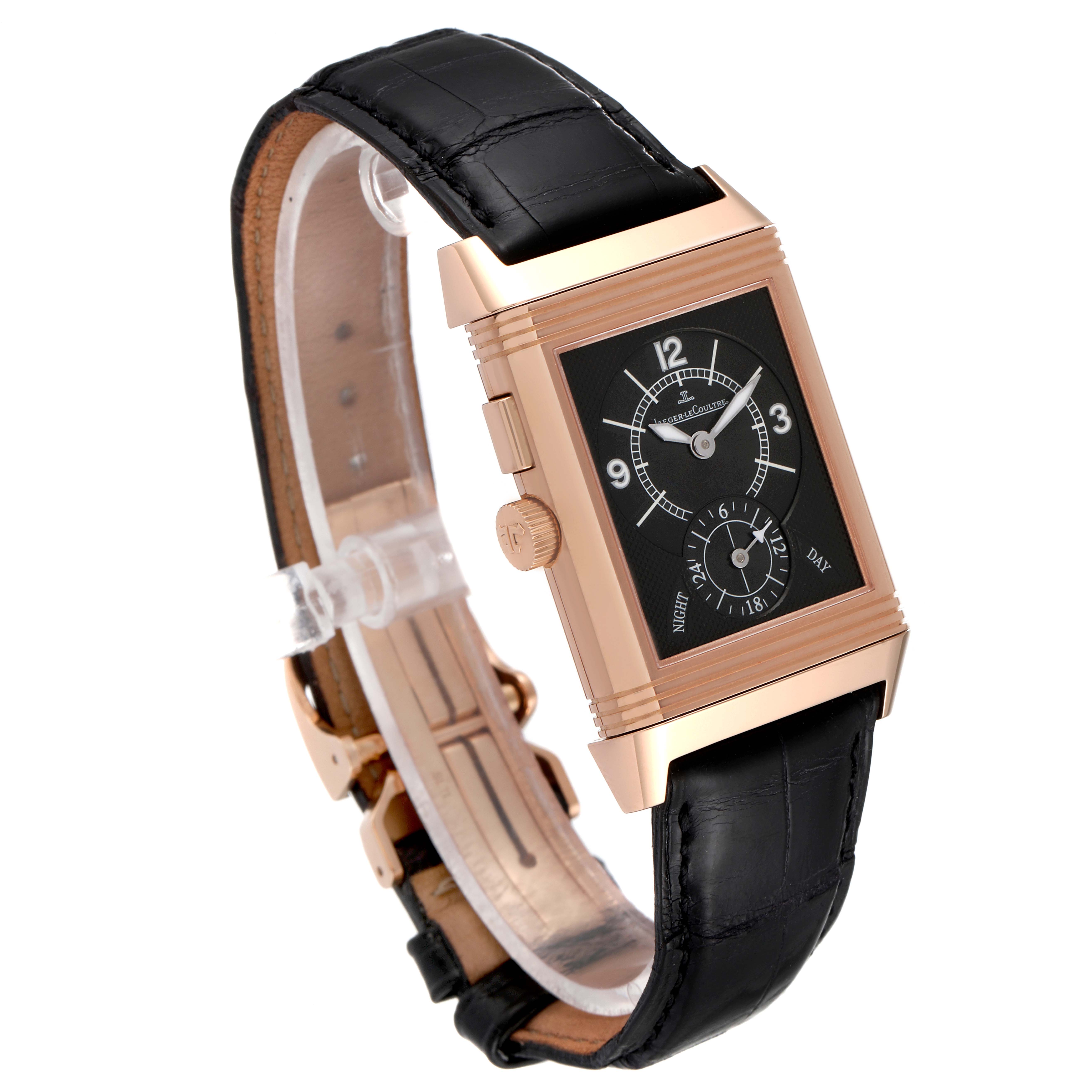 The Jaeger LeCoultre Reverso 272.2.54 Men's Rose Gold Silver Dial 272.2.54 Men's Rose Gold Silver Dial watch is shown at an angled view displaying its gold case, black dial, and leather strap.