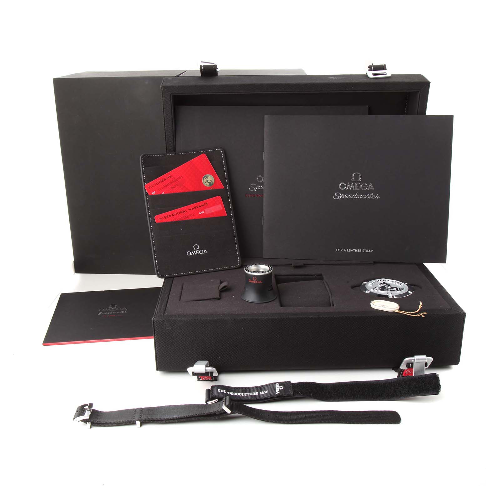 The image shows the Omega Speedmaster 311.30.40.30.01.001 Men's Stainless Steel Black Dial watch and its accessories, including a branded box, documentation, and a strap, viewed from the front.