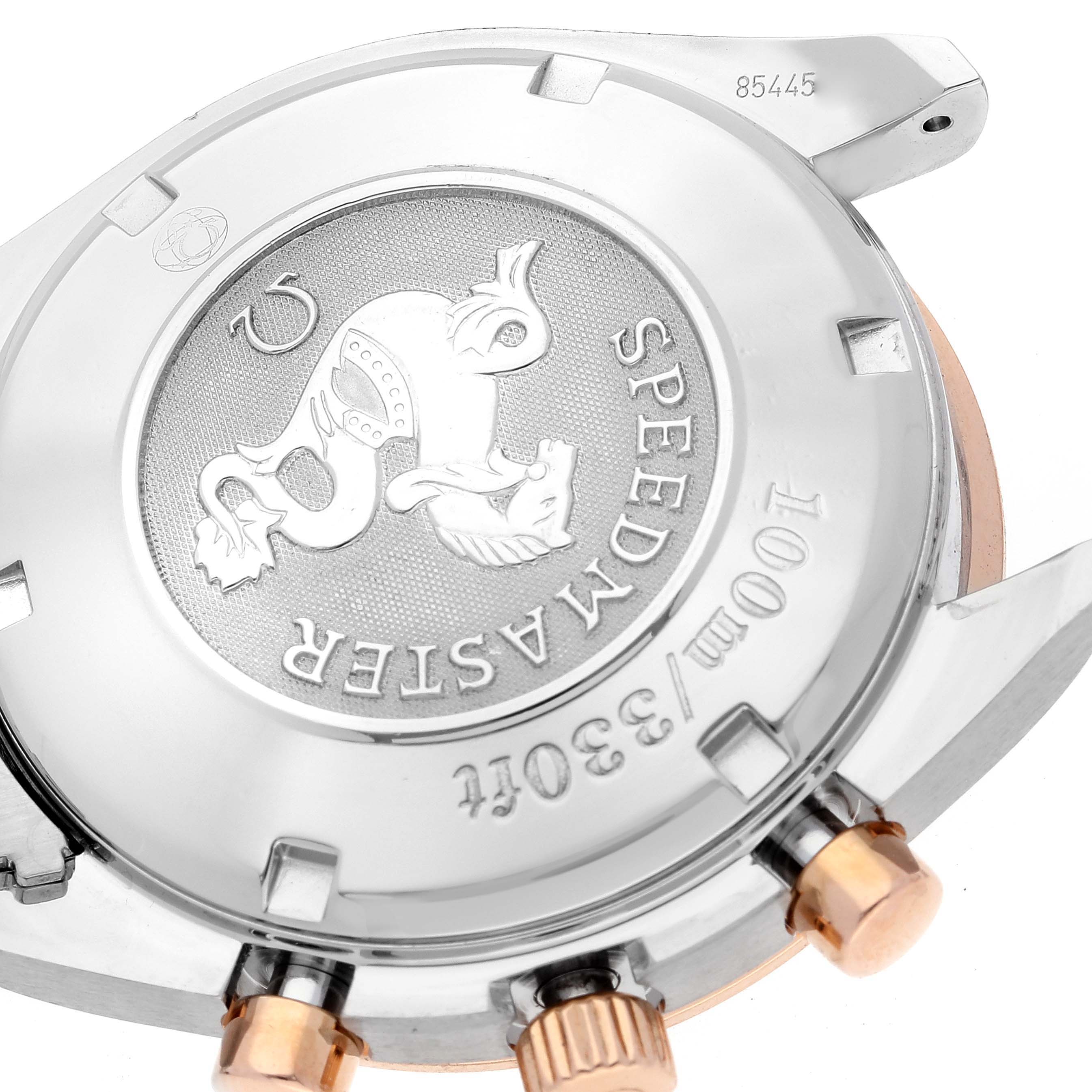 The image shows the case back of an Omega Speedmaster 323.21.40.40.01.001 Men's Steel and Gold (two tone) Black Dial 323.21.40.40.01.001 Men's Steel and Gold (two tone) Black Dial, highlighting the embossed emblem and part of the crown.