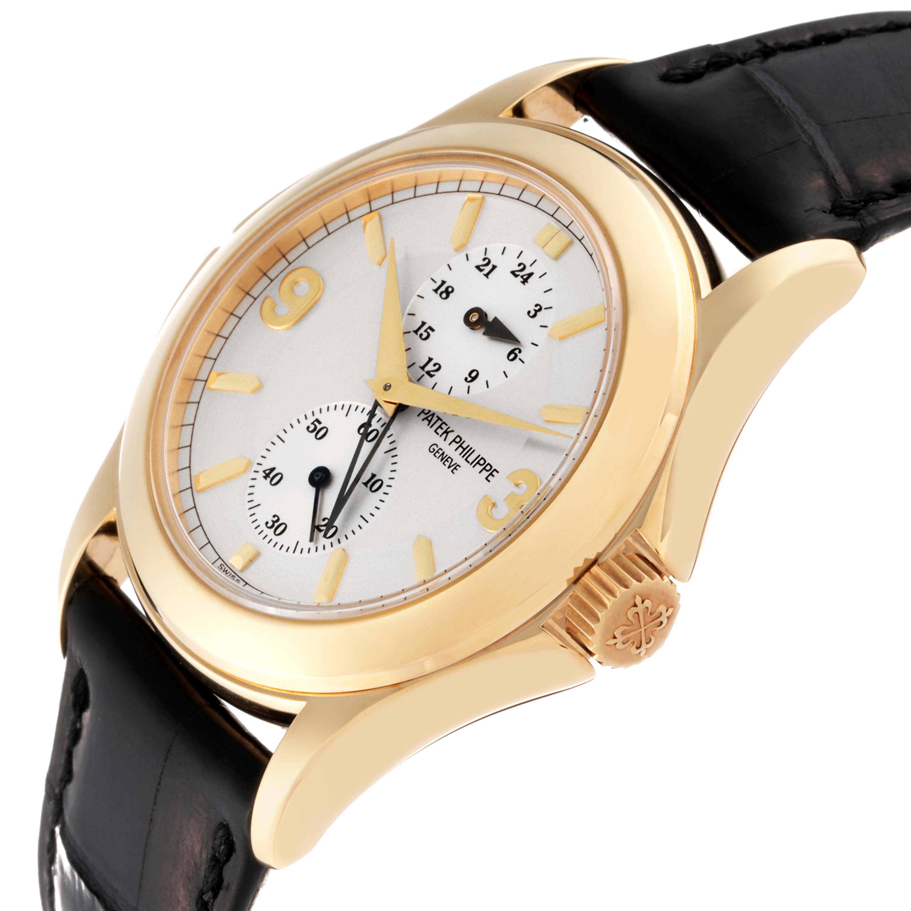 The Patek Philippe Calatrava 5134J Men's Yellow Gold Silver Dial 5134J Men's Yellow Gold Silver Dial watch is shown at an angle showcasing its face, crown, and a portion of its leather strap.