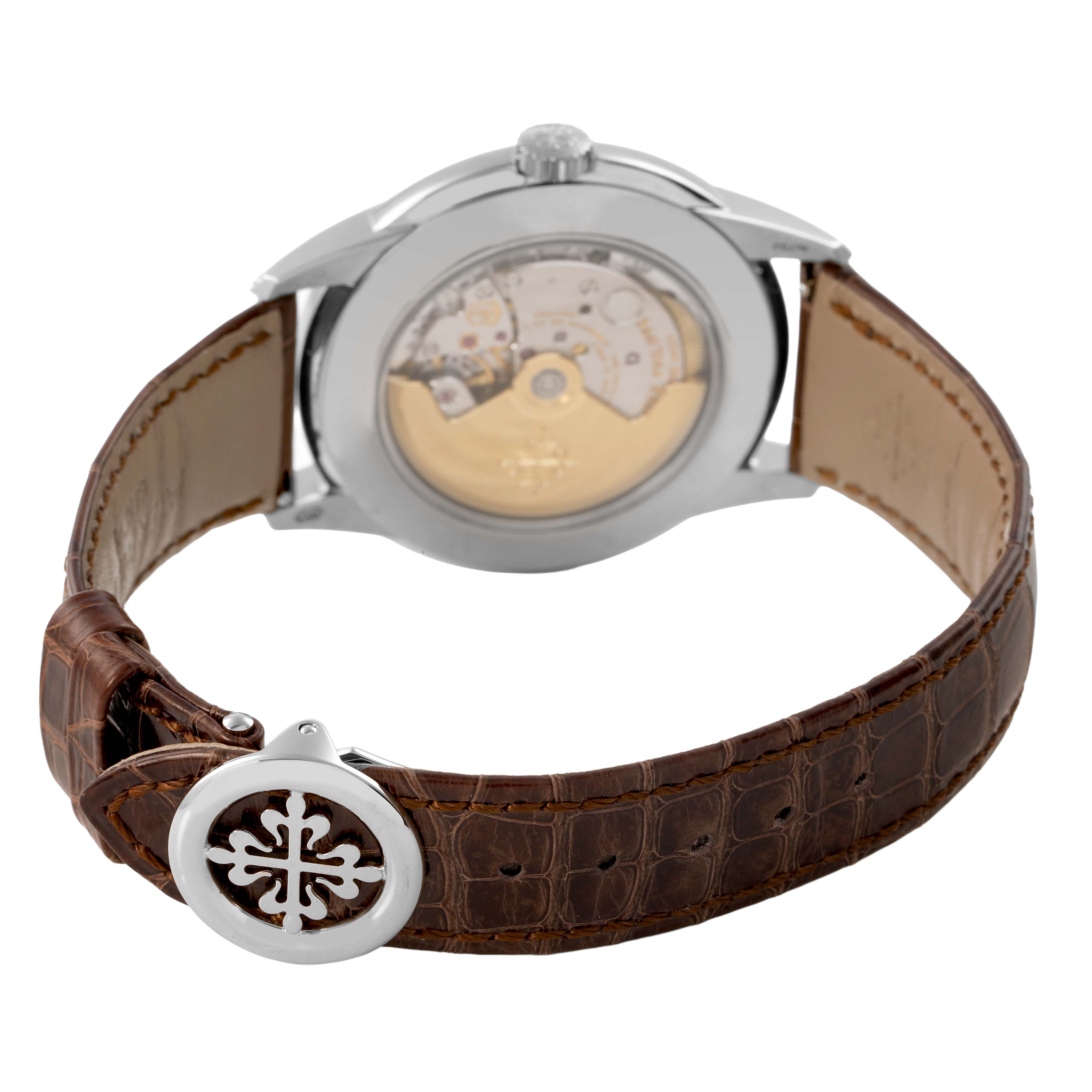 The image shows the back of the Patek Philippe Complications 5320G-001 Men's Yellow Gold White Dial watch, highlighting the movement and brown leather strap.