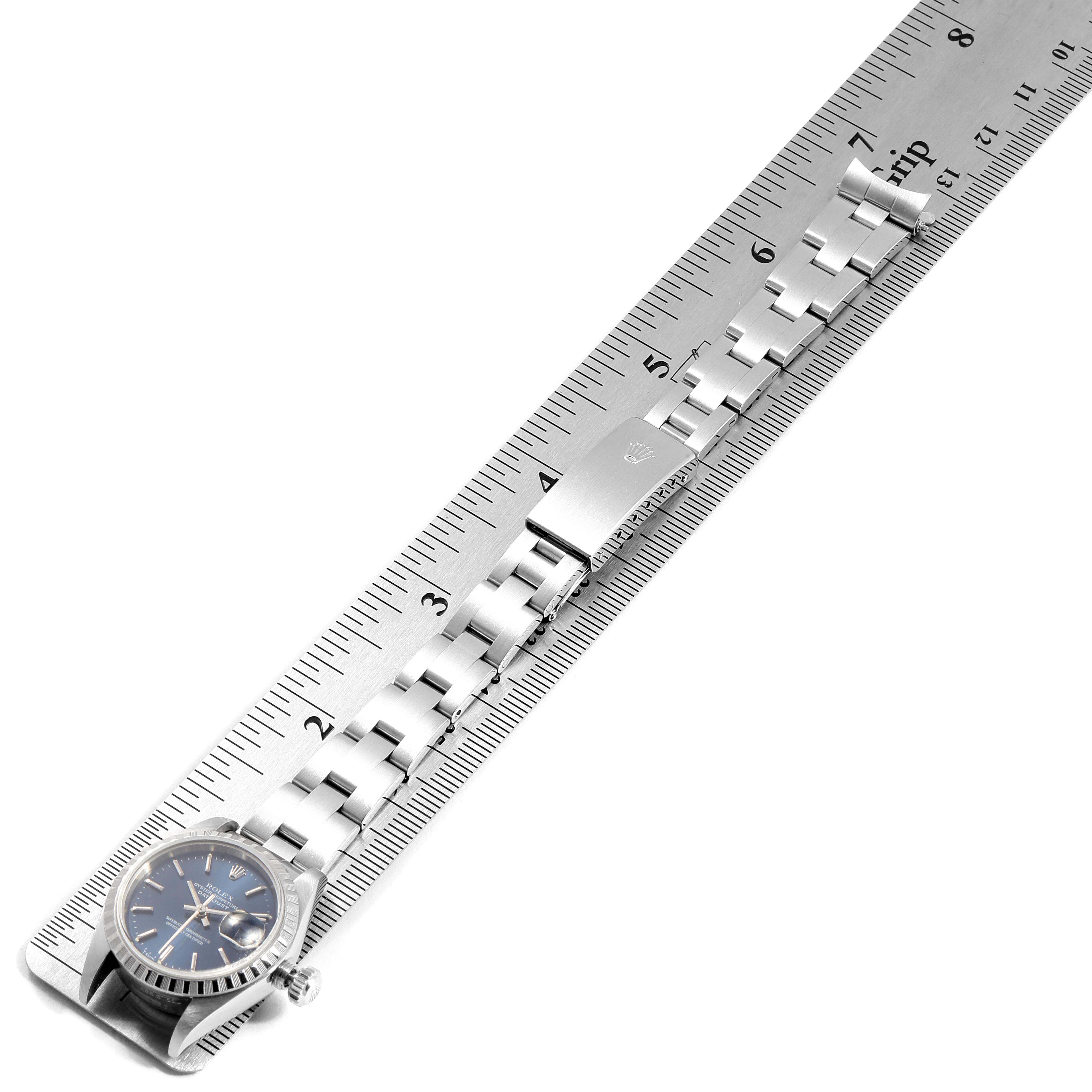 The image shows the Rolex Date 69240 Women
s Stainless Steel Blue Dial 69240 Women
s Stainless Steel Blue Dial model watch laying flat with its bracelet aligned to a metal ruler for measurement.