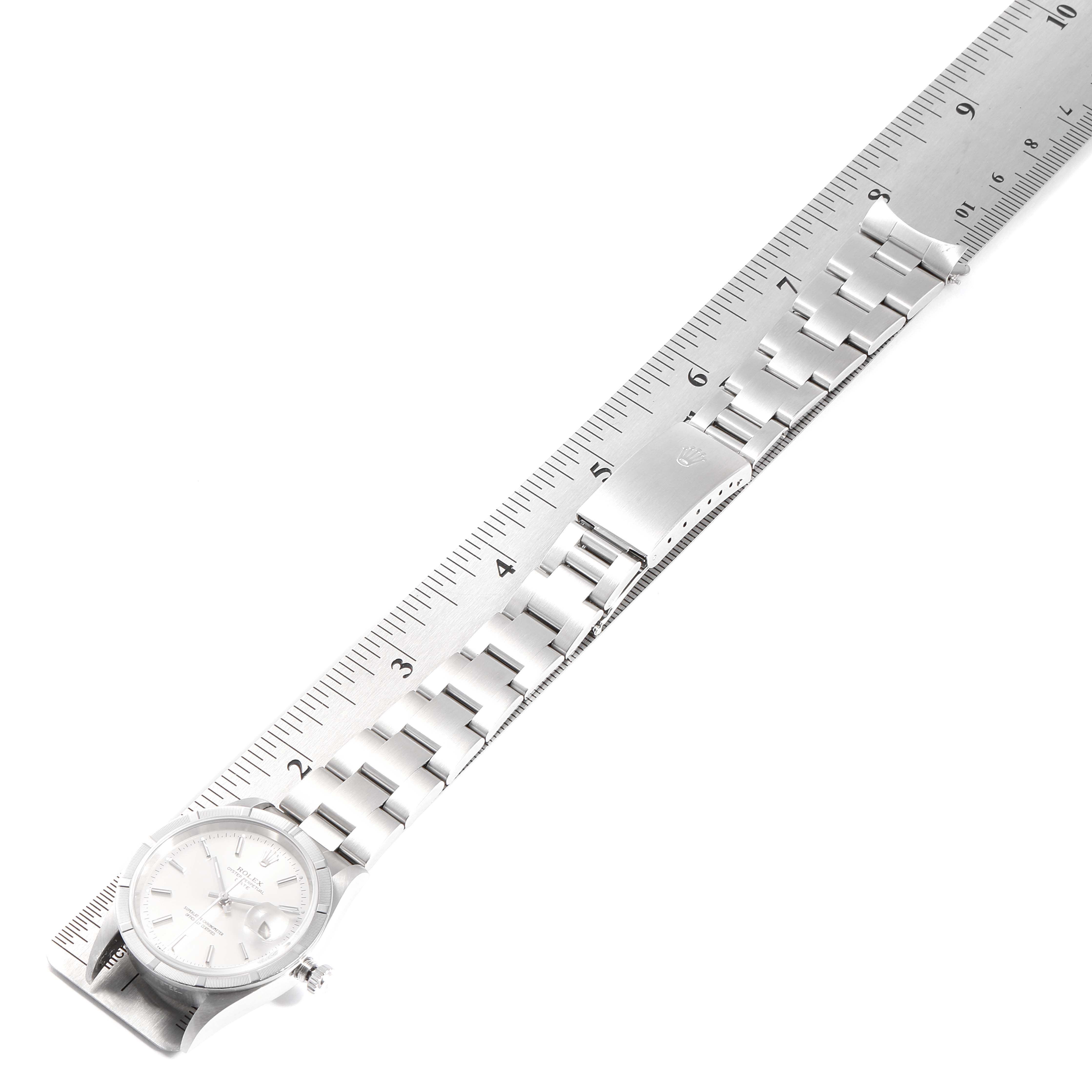 This image shows a Rolex Date 15210 Men's Stainless Steel Silver Dial 15210 Men's Stainless Steel Silver Dial model watch with its bracelet extended and aligned to a ruler, viewed from an overhead angle.