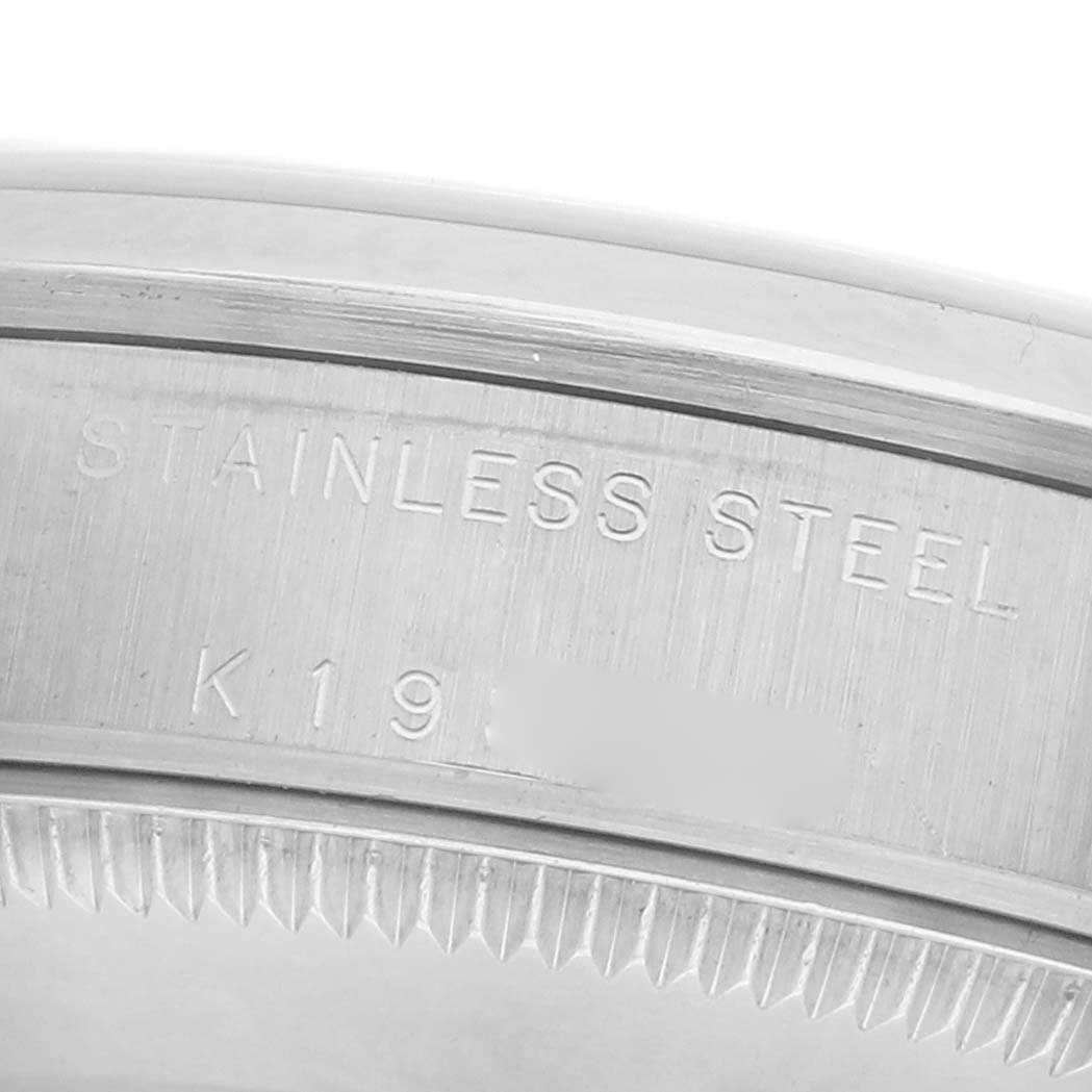 The image shows a close-up of the bezel edge and engraved text on a Rolex Mid-Size 78240 Women's Stainless Steel Pink Dial 78240 Women's Stainless Steel Pink Dial watch, highlighting its stainless steel material.