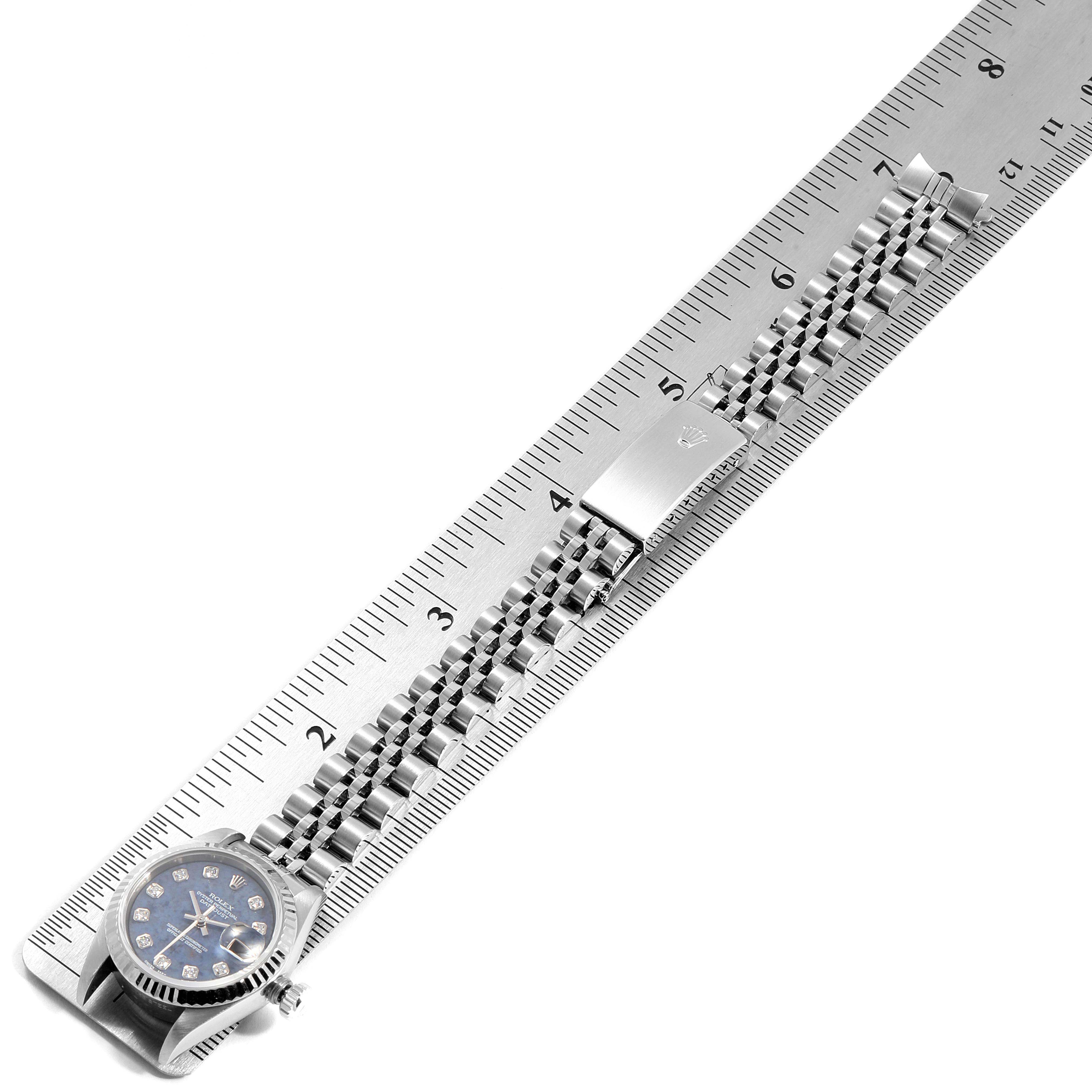 The image shows the Rolex Datejust 79174 Women
s Stainless Steel Blue Dial 79174 Women
s Stainless Steel Blue Dial watch laid flat on a ruler, displaying the face, bracelet, and clasp.