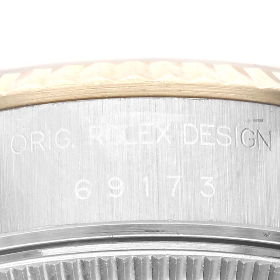 The image shows a close-up of the watch case side of a Rolex Datejust 69173G Women's Steel and Gold (two tone) Champagne Dial 69173G Women's Steel and Gold (two tone) Champagne Dial, focusing on the engraved model number and design text.