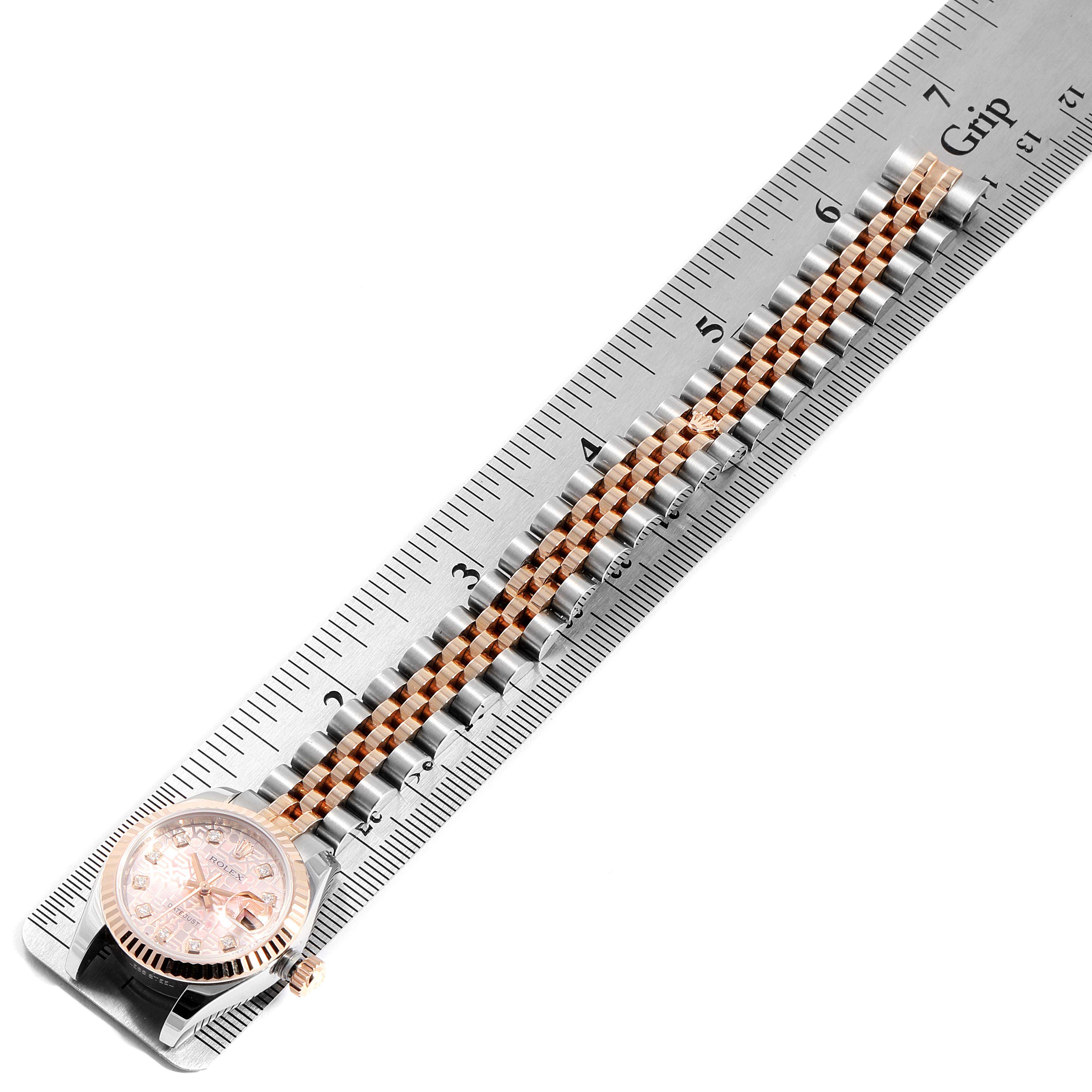 The image shows the face and partially extended band of a Rolex Datejust 179171 Women
s Steel and Gold (two tone) Pink Dial 179171 Women
s Steel and Gold (two tone) Pink Dial watch, positioned alongside a measuring scale.
