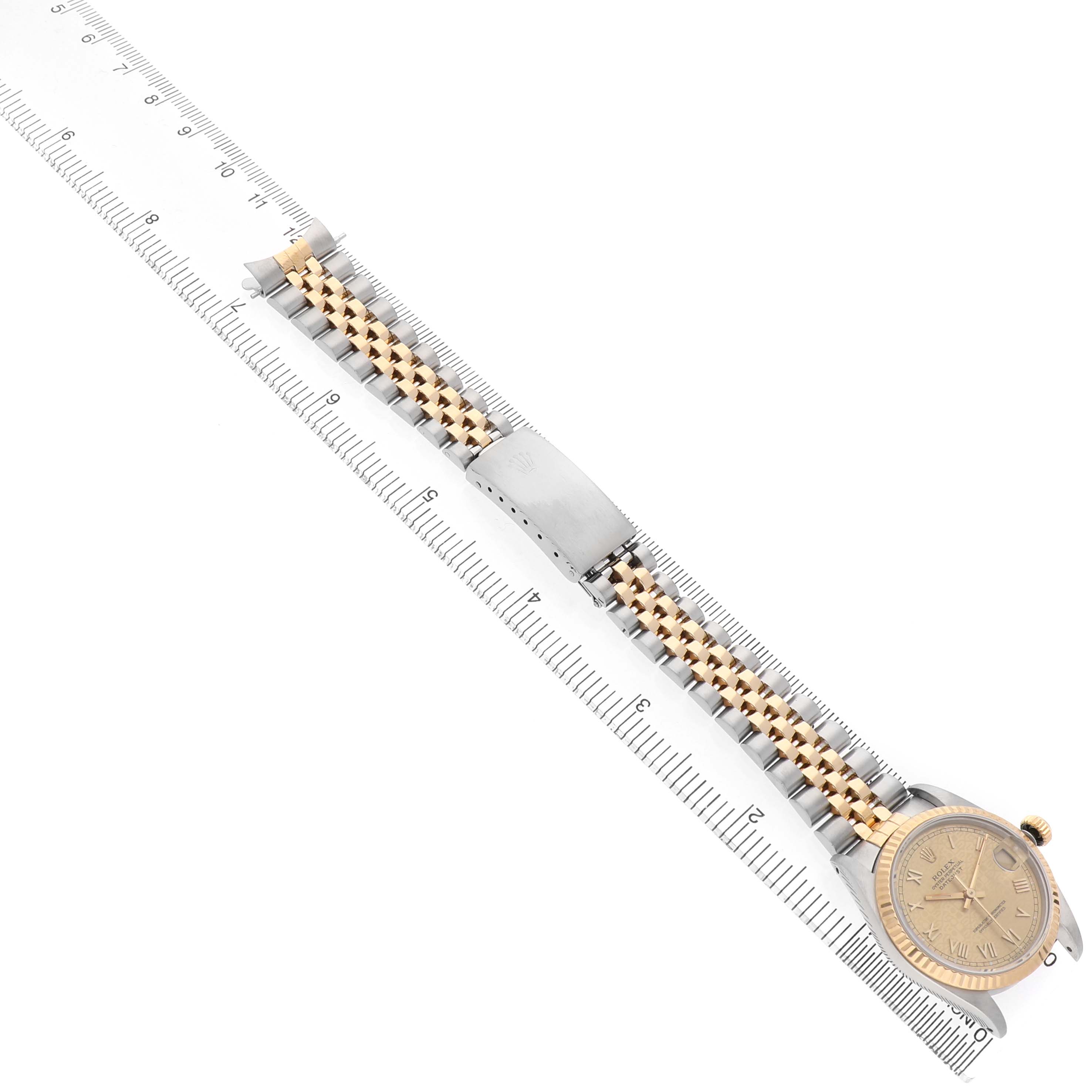 The image shows a top-down view of a Rolex Mid-Size 68273 Women's Steel and Gold (two tone) Champagne Dial watch, highlighting its face, bracelet, and clasp next to a ruler.