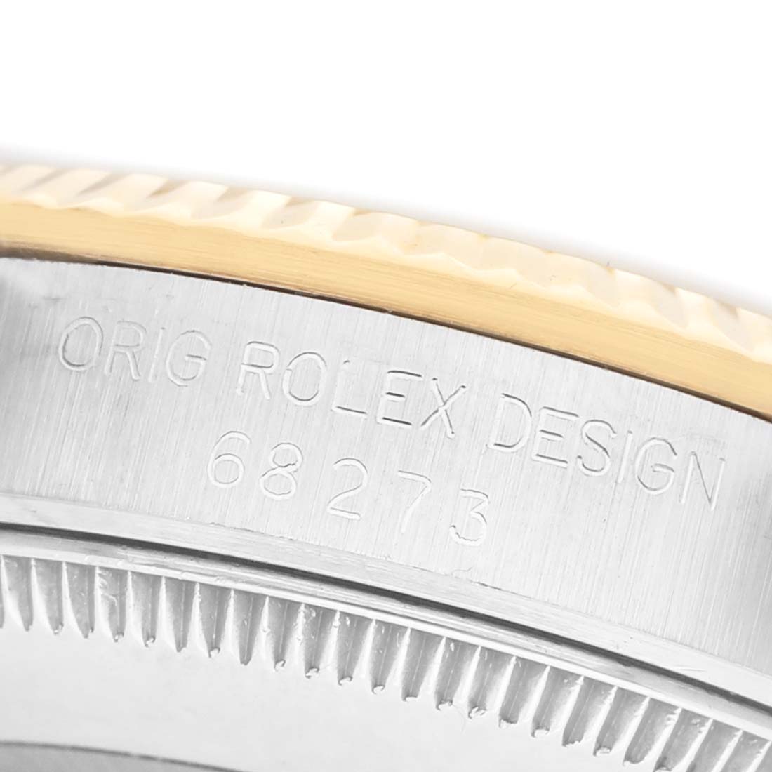 The image shows a close-up of the side case and bezel of a Rolex Mid-Size 68273 Women's Steel and Gold (two tone) Champagne Dial model, featuring engraved text and fluted edges.