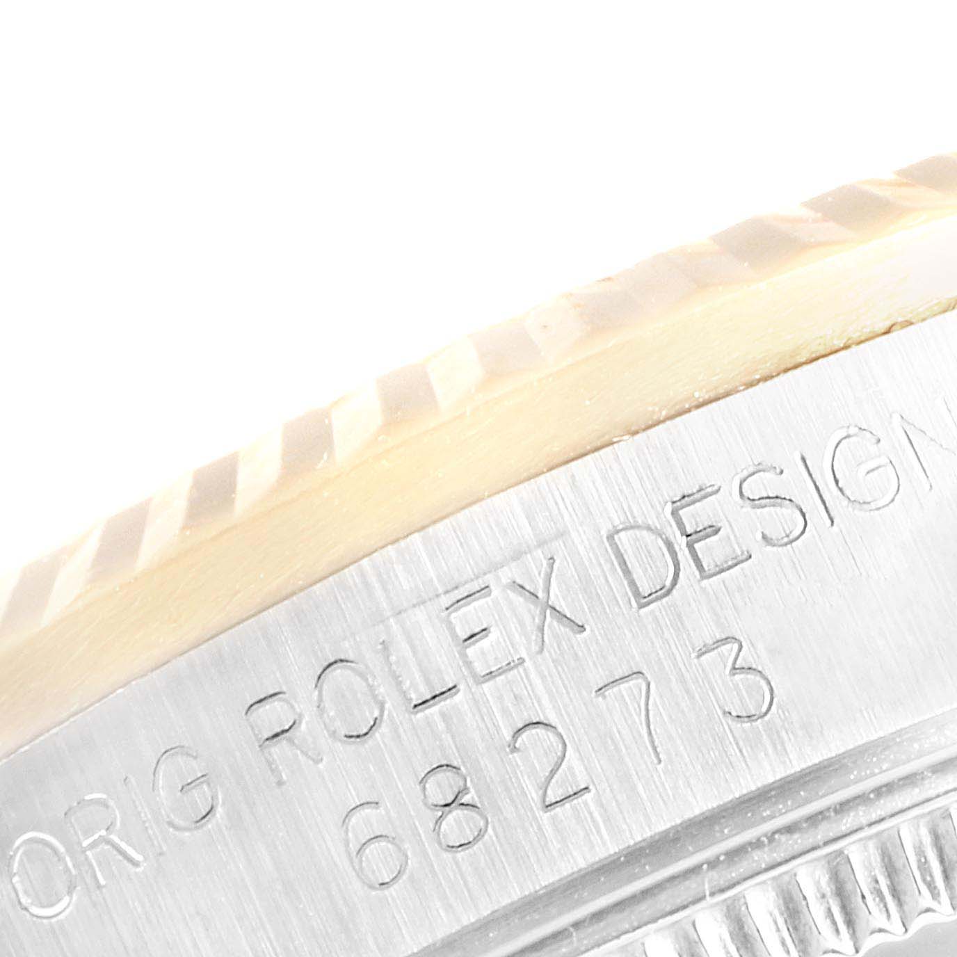 This close-up angle of a Rolex Mid-Size 68273 Women
s Steel and Gold (two tone) Champagne Dial 68273 Women
s Steel and Gold (two tone) Champagne Dial watch shows the bezel and part of the engraved model number "68273."