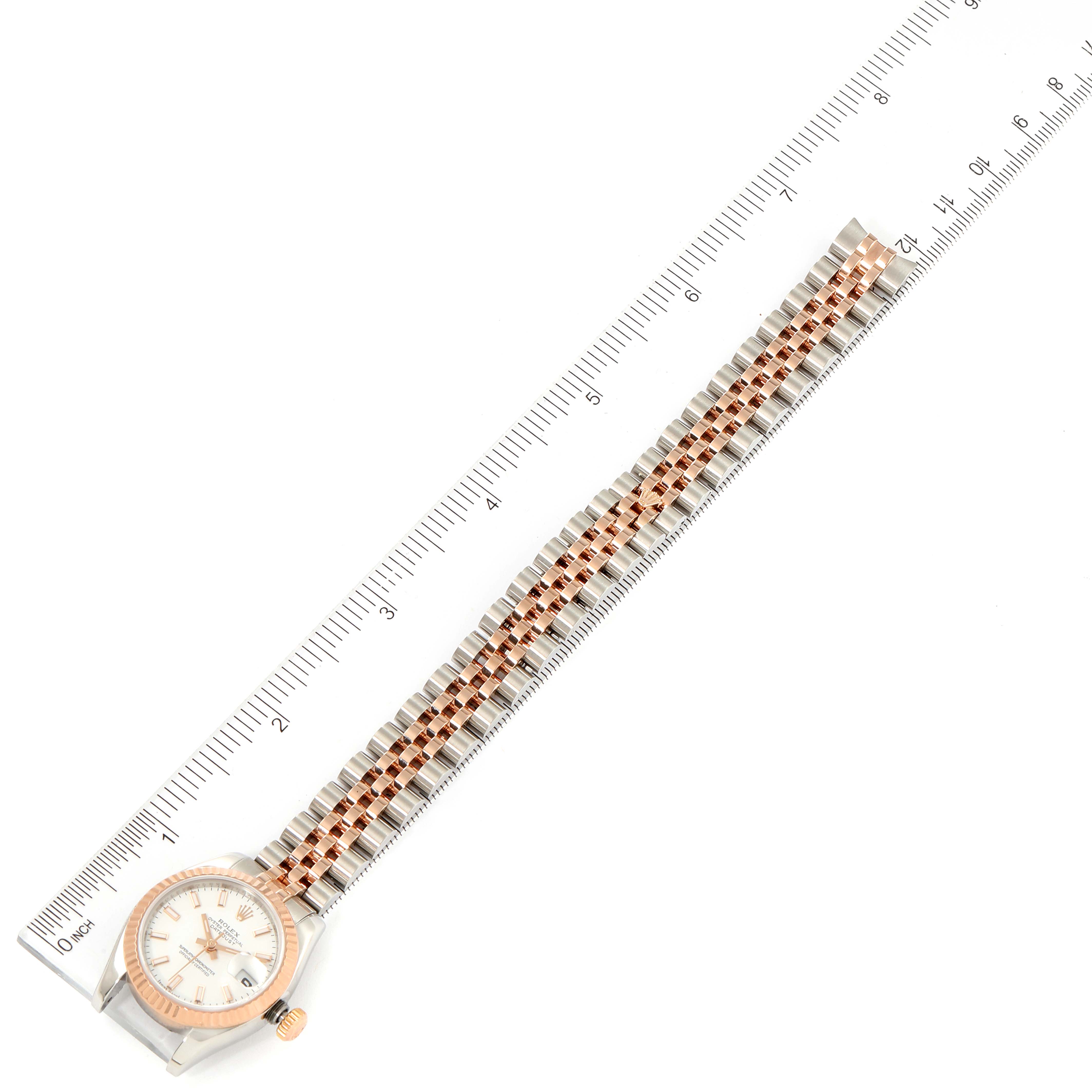 The image shows a top-down view of a Rolex Datejust 179171 Women
s Steel and Gold (two tone) White Dial 179171 Women
s Steel and Gold (two tone) White Dial watch, focusing on the bracelet and face next to a ruler.