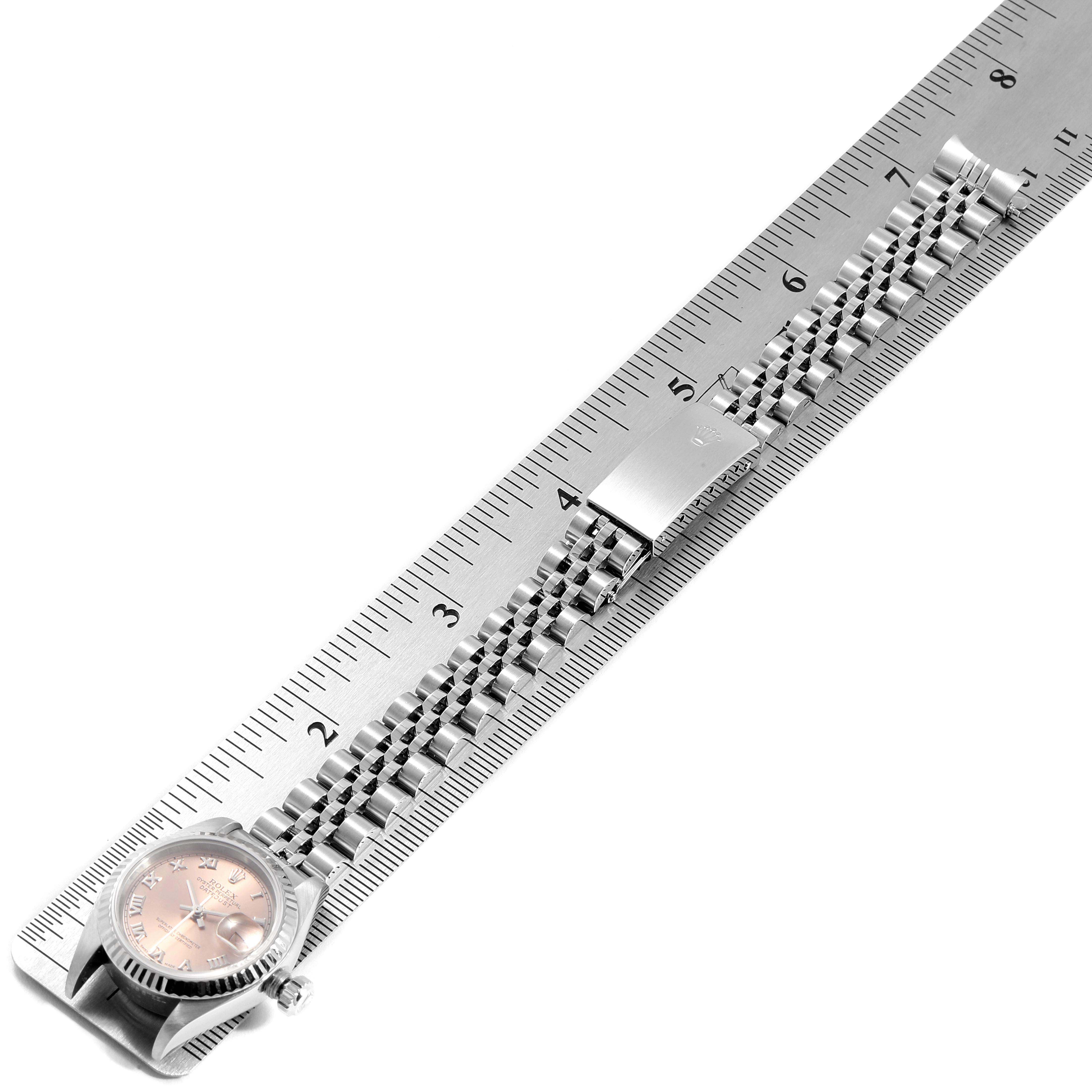 The image shows a Rolex Datejust 79174 Women
s Stainless Steel Pink Dial 79174 Women
s Stainless Steel Pink Dial watch and its bracelet, measured against a ruler.