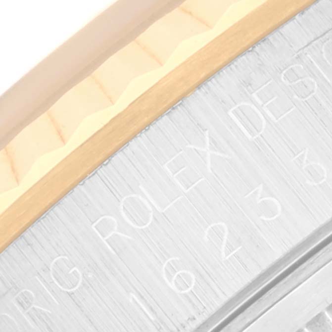 This close-up image shows the side view of the bezel and the engraved case of a Rolex Datejust 16233 Men's Steel and Gold (two tone) Blue Dial 16233 Men's Steel and Gold (two tone) Blue Dial model.