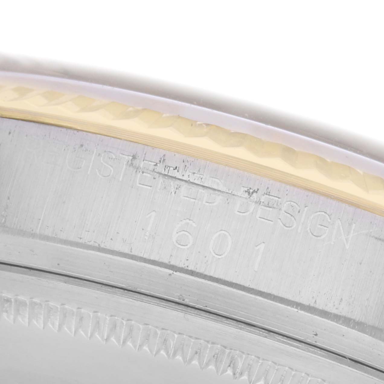 The image shows a close-up of the edge of the bezel and case back of a Rolex Datejust 1601 Men's Steel and Gold (two tone) Champagne Dial 1601 Men's Steel and Gold (two tone) Champagne Dial model, highlighting engravings.