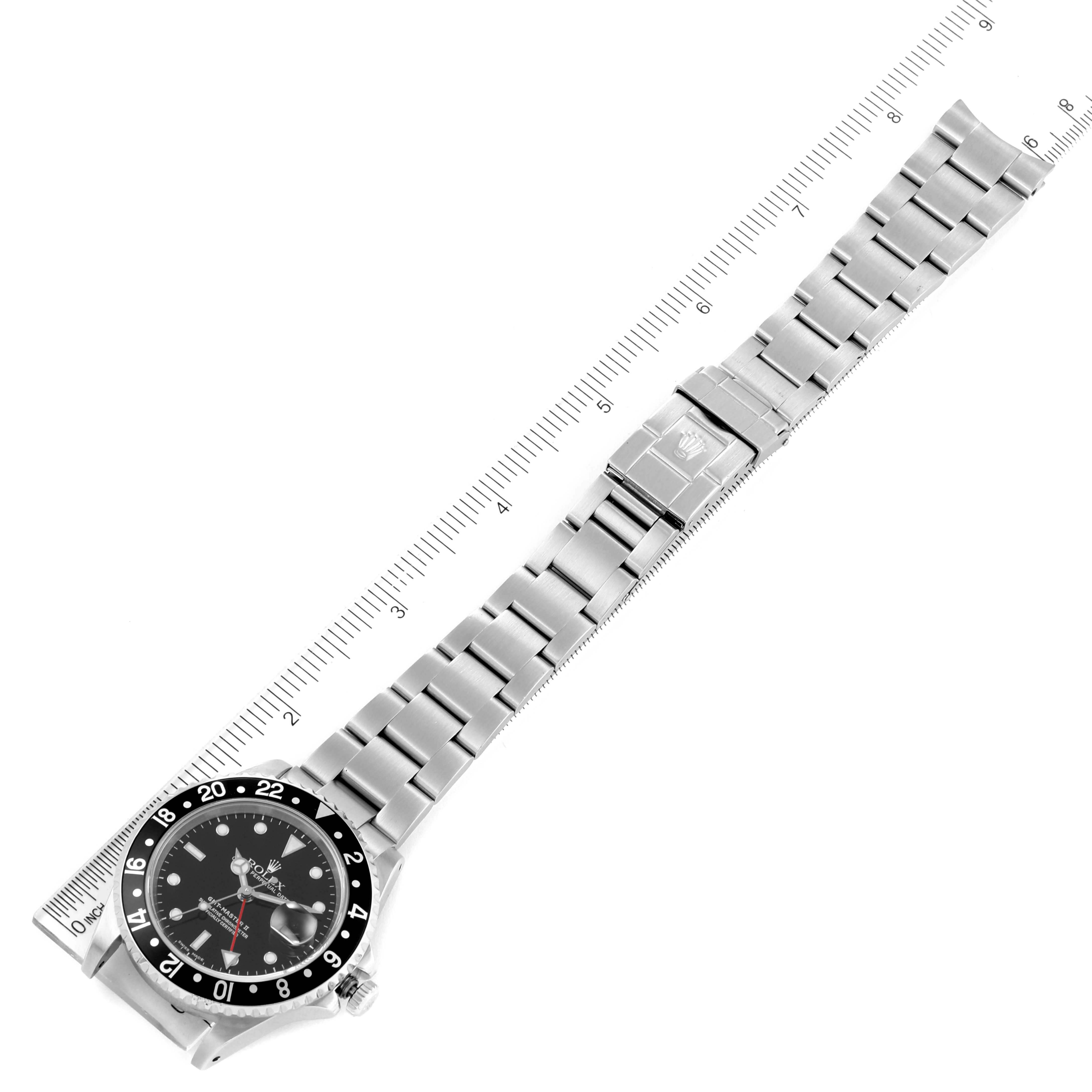 The image shows a top view of a Rolex GMT-Master 16710 Men's Stainless Steel Black Dial 16710 Men's Stainless Steel Black Dial watch with its full bracelet extended alongside a ruler for scale.