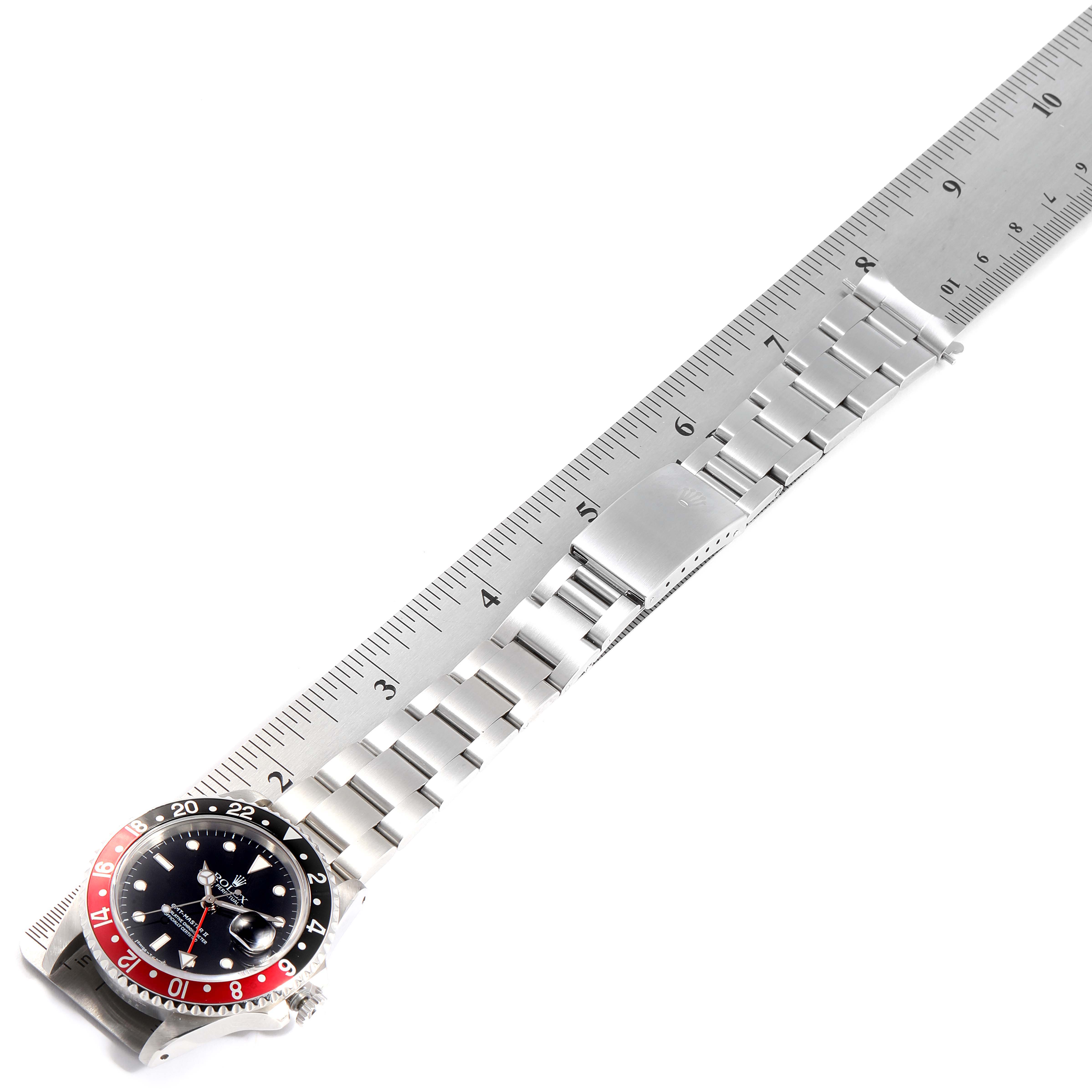 The Rolex GMT-Master 16710 Men
s Stainless Steel Black Dial 16710 Men
s Stainless Steel Black Dial watch is displayed with its bracelet fully extended alongside a ruler from an overhead angle.